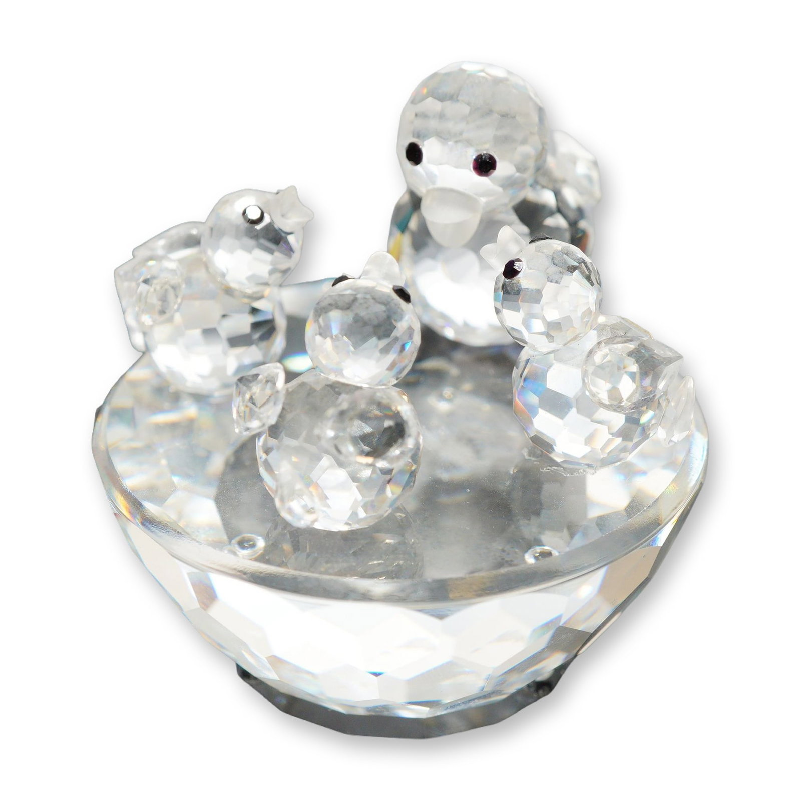 Swarovski Crystal Figurine, Ducks on a Pond: Ducks on a Pond figurine in faceted clear lead crystal, featuring a mother duck and three ducklings clustered on a semi-spherical faceted base. The mother duck is detailed with dark colored eyes. Acid
