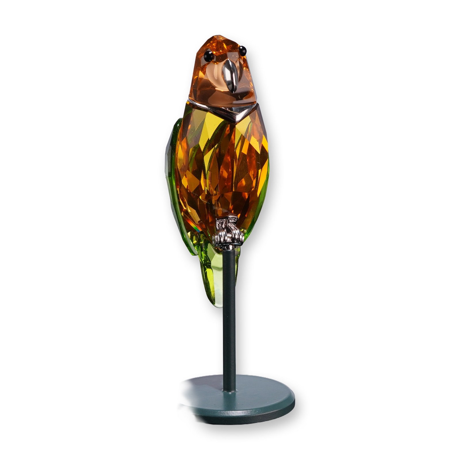 Swarovski Crystal Paradise Birds Figurine, Bebotto Jonquil: The piece features a faceted jonquil yellow and orange crystal body with green crystal wings and tail. The bird is mounted on a sterling silver perch assembly, stamped with the Swarovski swan logo, an