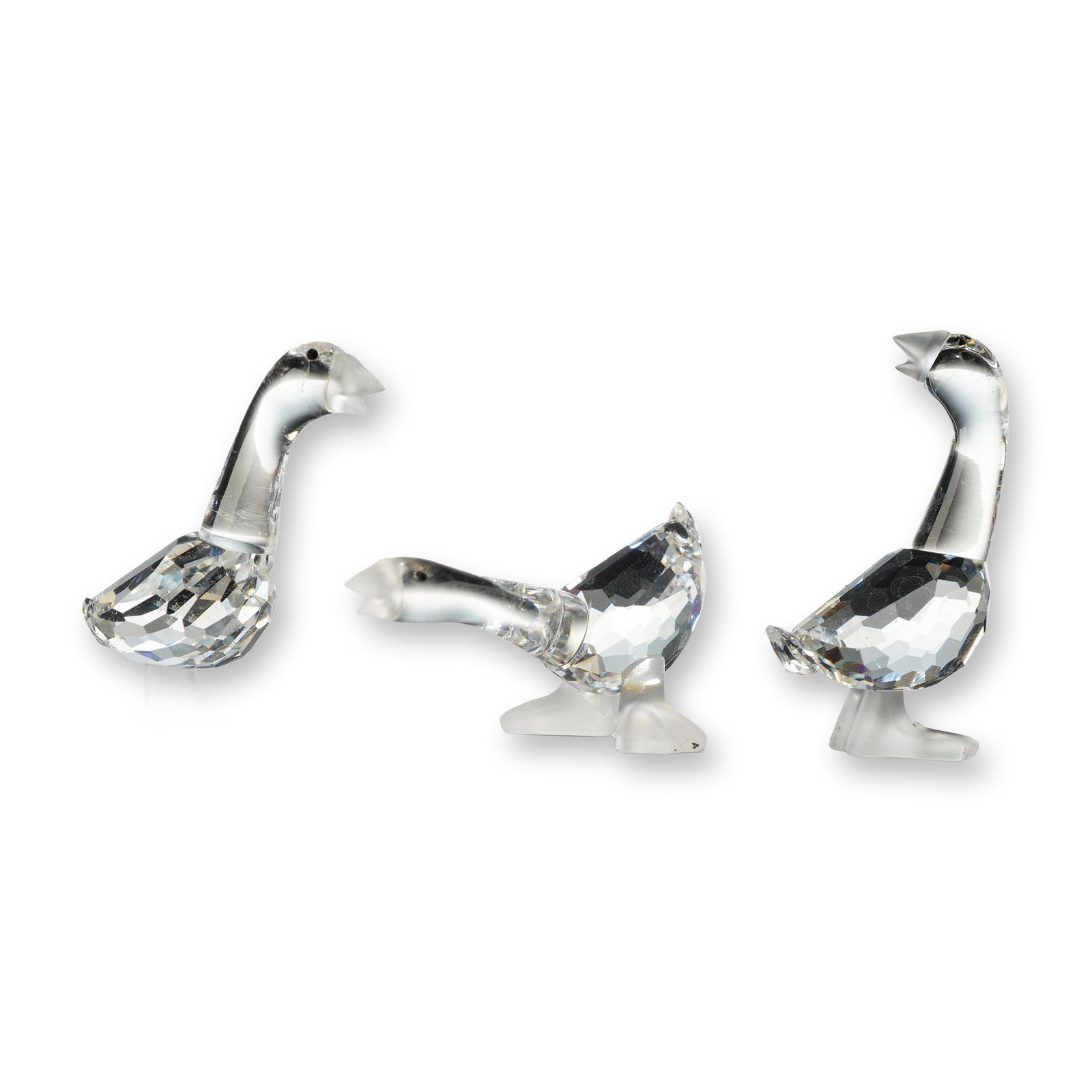 Swarovski Silver Crystal Figurines, Goslings: Tom, Dick and Harry Gosling figurines in faceted lead crystal with molded smooth crystal necks and heads. The set features geese in three distinct poses: grazing with neck extended, standing upright, 
