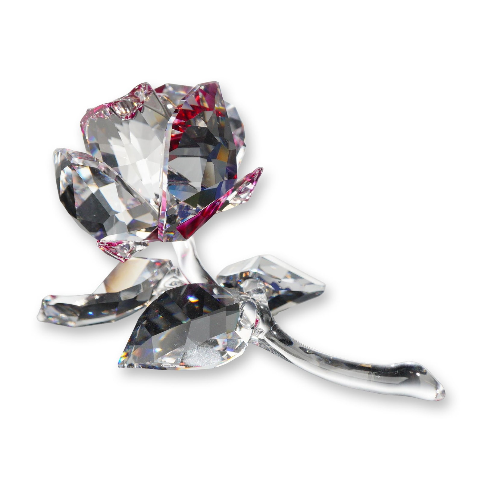 Swarovski Crystal Blossoming Rose Figurine: Swarovski. A Blossoming Rose figurine in faceted lead crystal, featuring a blooming flower head with clear faceted petals accented with pink tones near the center. The flower head is supported by a cu