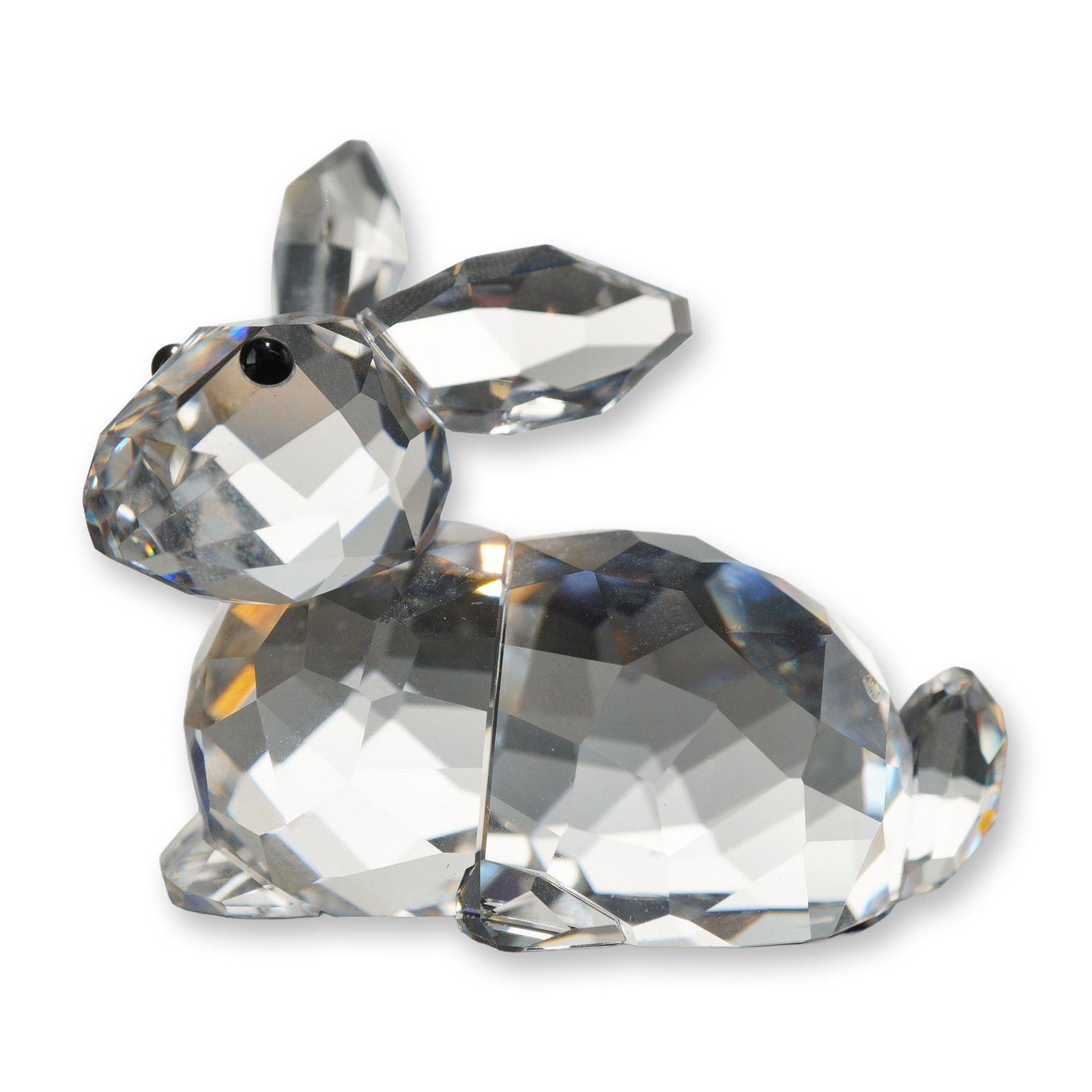 Swarovski Crystal Lying Rabbit Figurine: Swarovski crystal lying rabbit figurine, model number 905778. Crafted in faceted clear lead crystal with two small black crystal eyes, alert pointed ears, and an upturned tail. Marked on the underside