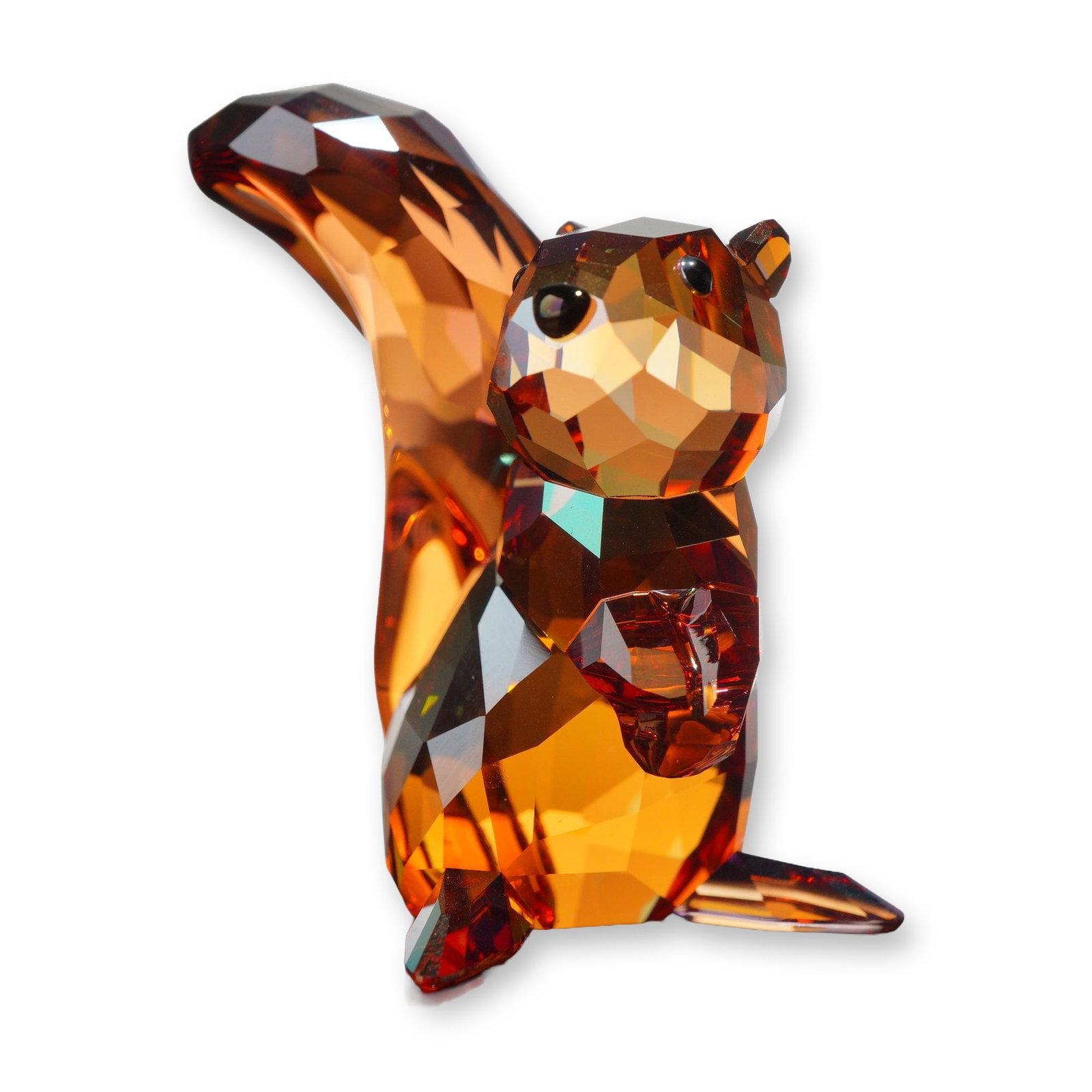 Swarovski Crystal Copper Squirrel Figurine 1142807: Swarovski. Figurine in copper-colored faceted crystal, depicting a standing squirrel holding an acorn, model number 1142807. The figure is constructed with jet-black crystal eyes and features iridesce