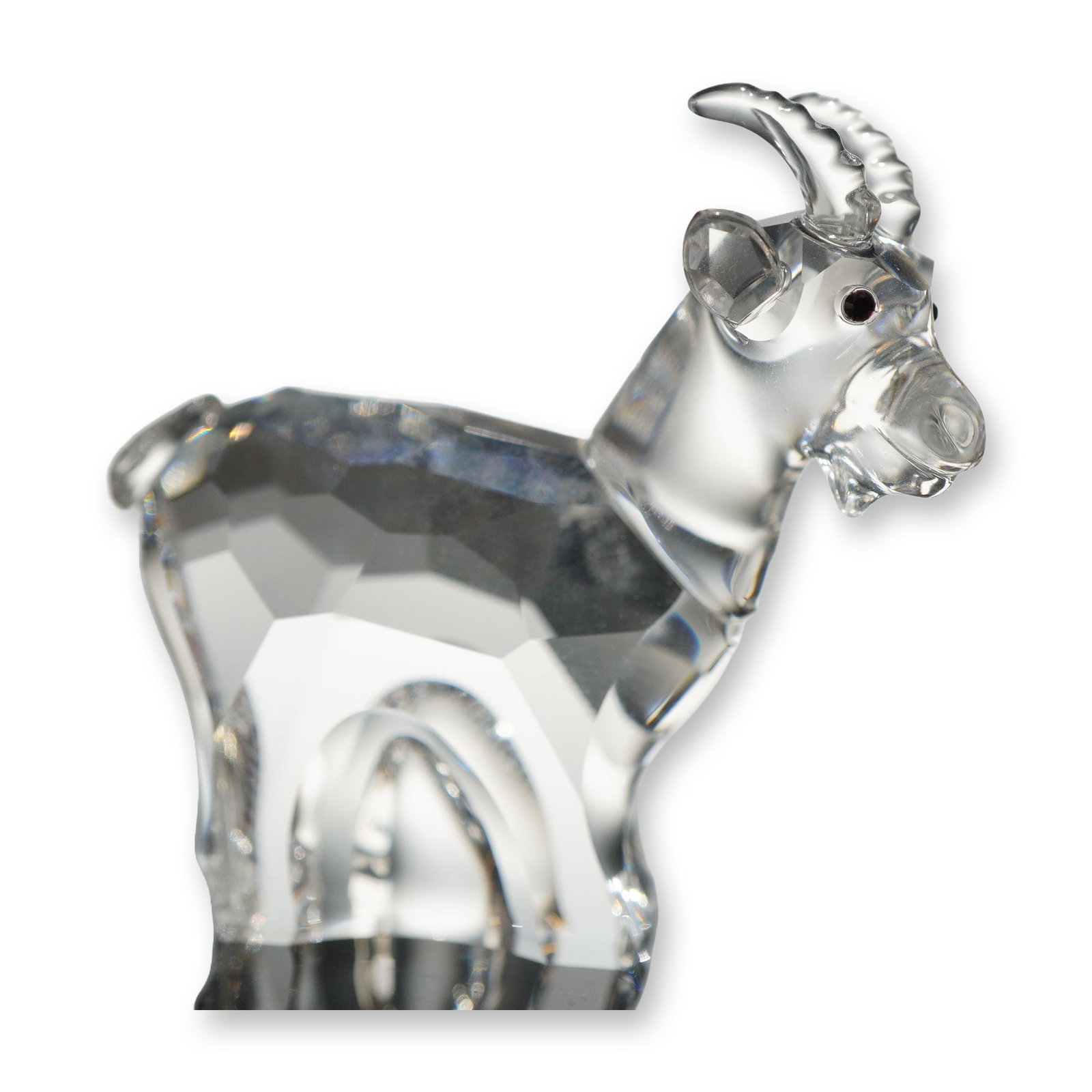 Swarovski Crystal Chinese Zodiac Goat Figurine: Swarovski Chinese zodiac goat figurine in clear faceted lead crystal. The standing figure features a faceted body, smooth neck and head, molded ribbed horns, and applied black cabochon crystal eyes. S