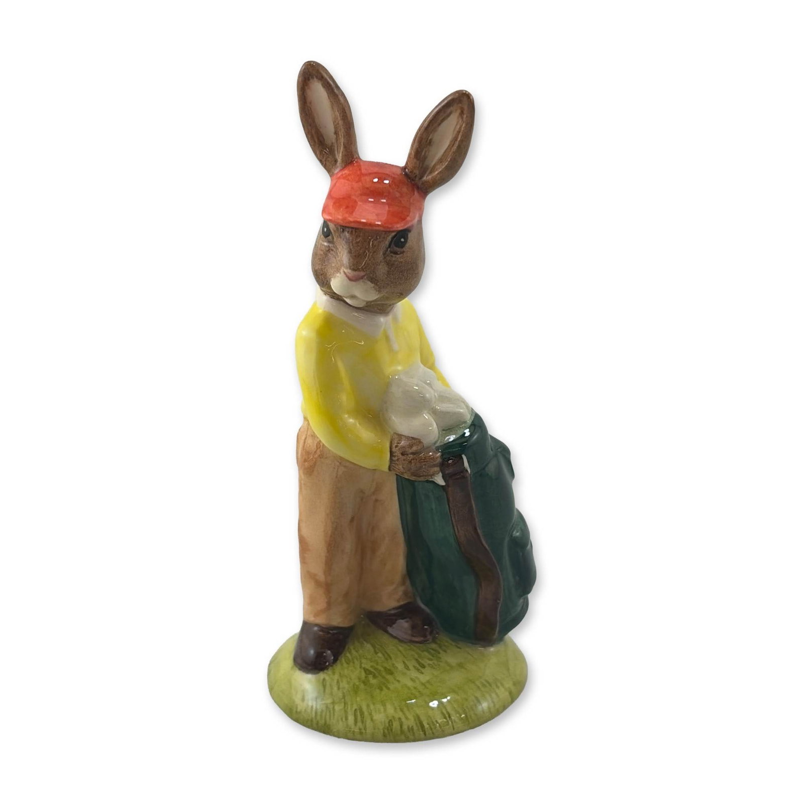 Royal Doulton Caddie Bunnykins Porcelain Figurine DB271: Royal Doulton porcelain figurine from the Bunnykins collection, titled Caddie, model DB 271. The hand-painted figure depicts a rabbit dressed in a yellow sweater, tan trousers, and red visor, carrying