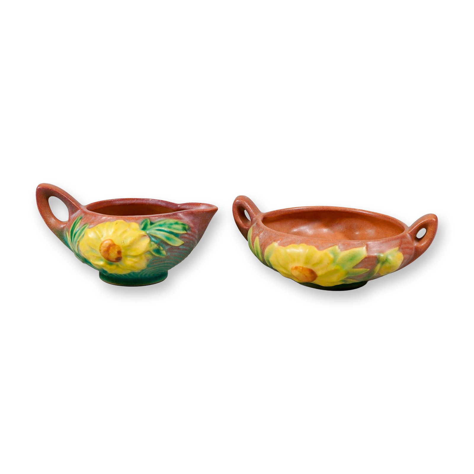 Two-Piece Roseville Pottery Peony Pattern Grouping: A two-piece Roseville Pottery grouping in the Peony pattern, first introduced in 1942. The set includes a Peony creamer with a single handle and pinched spout, and a low, double-handled bowl. Each pie