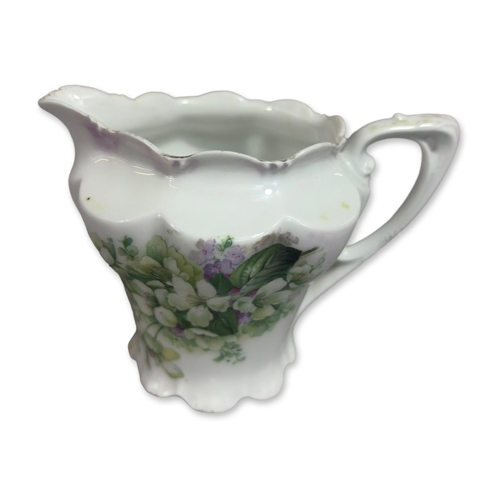 RS Prussia Porcelain Floral Motif Creamer: RS Prussia porcelain creamer by Reinhold Schlegelmilch. The vessel features a bulbous, lobed body tapering to a flared scalloped base, with a ruffled rim and an ornate, high-arched handle. The