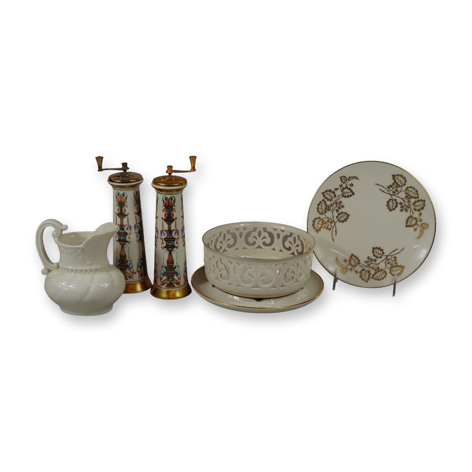 6pc Lenox Ashtray, Plate, Bowl, Pitcher, and Pepper Grinders: This lot consists of a six-piece collection of fine cream-colored porcelain produced by Lenox in the USA. The grouping includes two tall cylindrical pepper grinders featuring gold-toned metal grinding