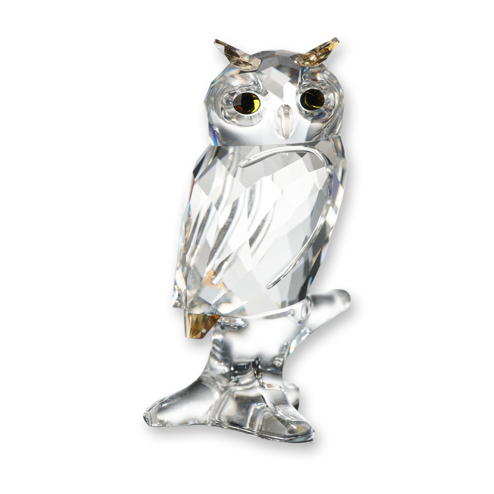 Swarovski Owl Crystal Figurine, 5043988: Swarovski. The clear faceted owl is depicted perched on a frosted crystal branch with amber-toned crystal accents at the ear tufts and tail. The eyes are inset with golden-amber faceted crystal and da