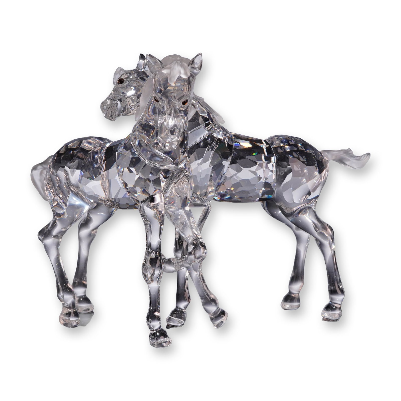 Swarovski Crystal Foals Figurine: Swarovski clear crystal figurine titled Foals, model number 627637. The piece depicts two young horses in an interactive pose, featuring faceted bodies and smooth molded manes, tails, and legs. The ey