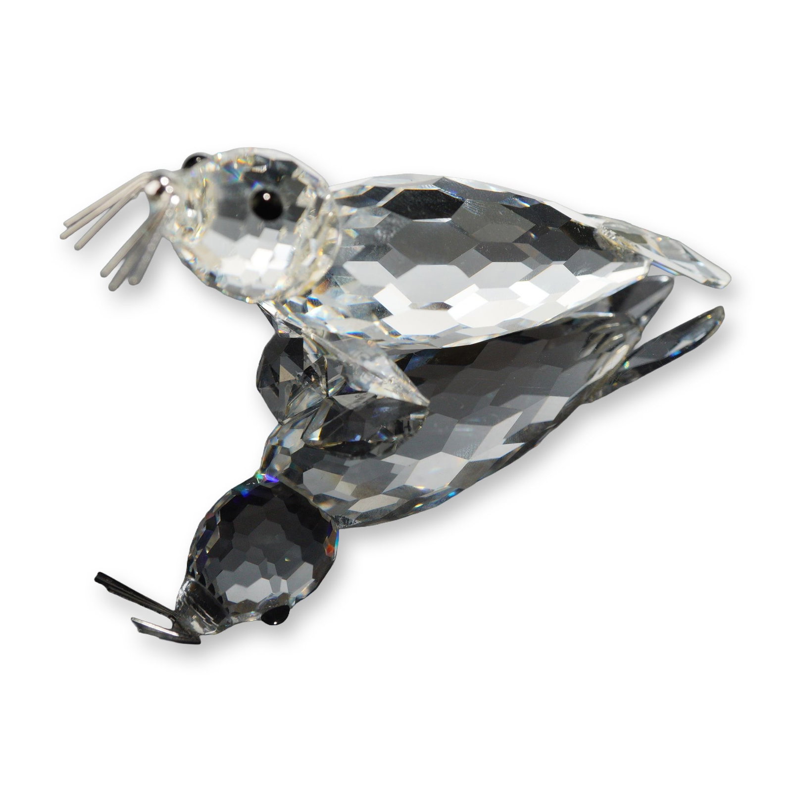 Swarovski Crystal Seal Figurine with Original Box: Swarovski, Austria. Reclining seal figurine in faceted lead crystal from the Silver Crystal line. The animal form features a multi-faceted body and head, two black circular elements for eyes, and fine