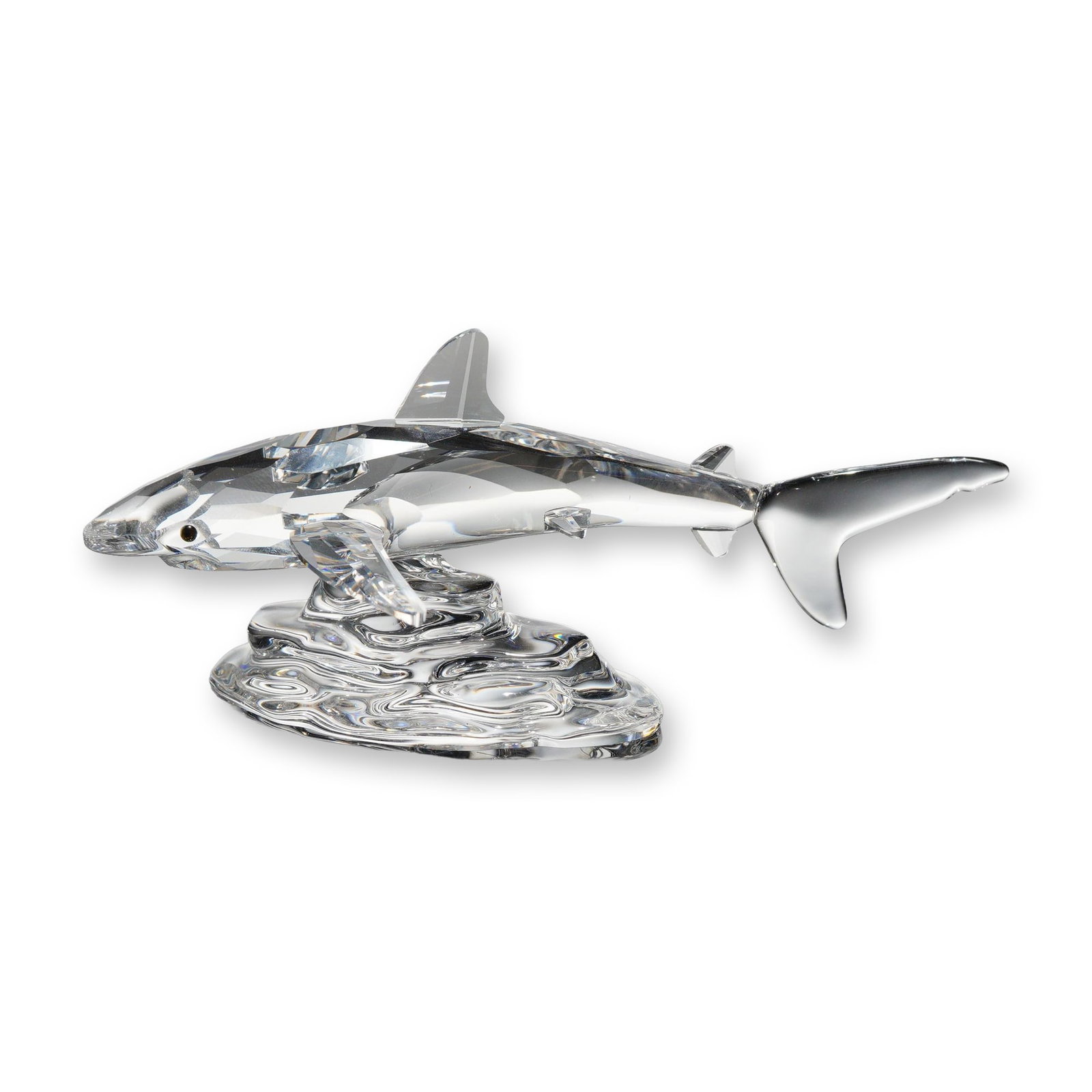 Swarovski Silver Crystal Baby Shark Figurine: Swarovski Silver Crystal figurine, Baby Shark model, crafted in faceted and molded lead crystal. The piece depicts a shark in a leaping pose over a stylized wave base. Featuring a precision-faceted bo
