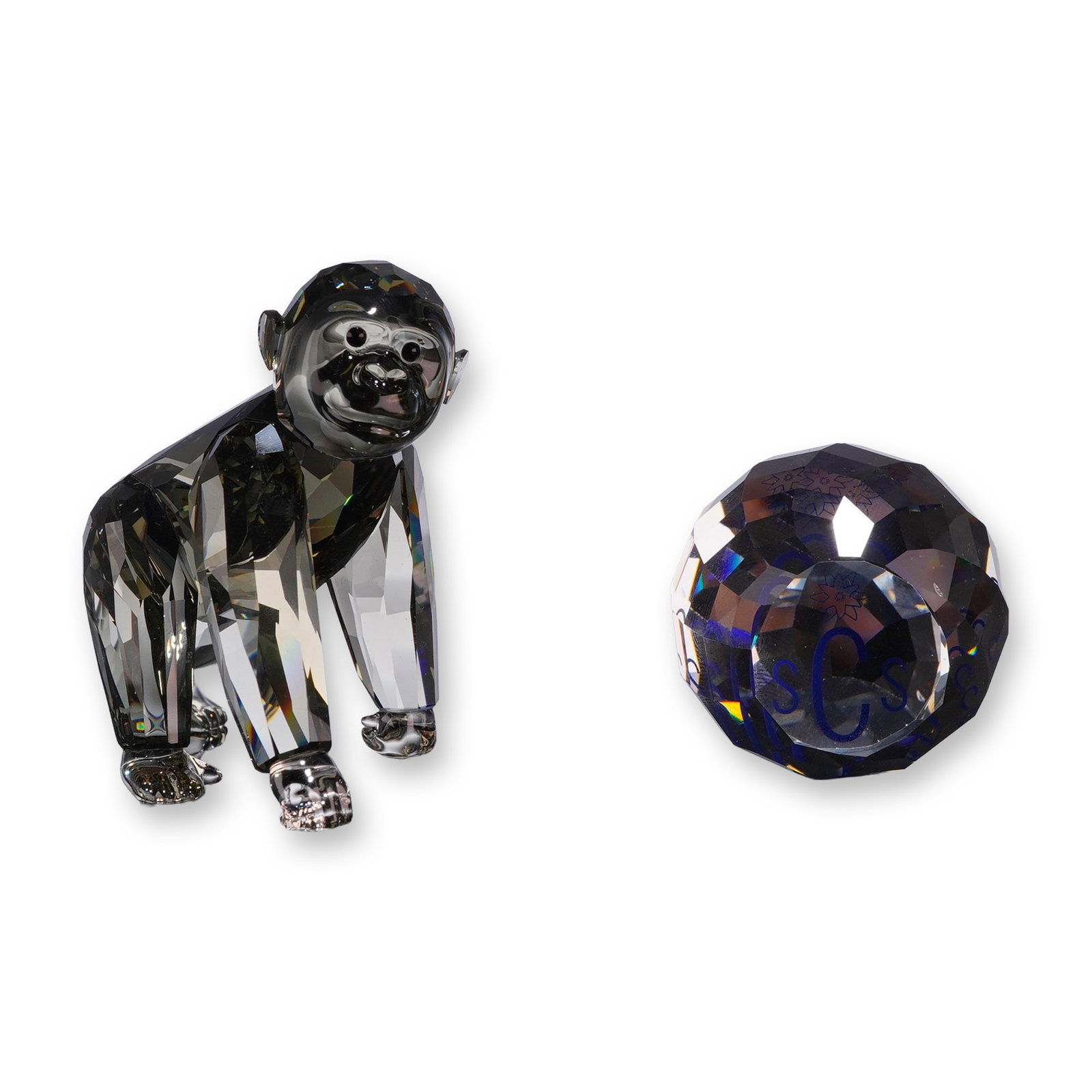 Swarovski Crystal 2009 Annual Edition Gorilla Cub Figurine and SCS Paperweight: Swarovski Crystal Society members exclusive Gorilla Cub figurine in smoked grey crystal and coordinating faceted crystal paperweight with a blue central accent. The gorilla figurine features a laser-e