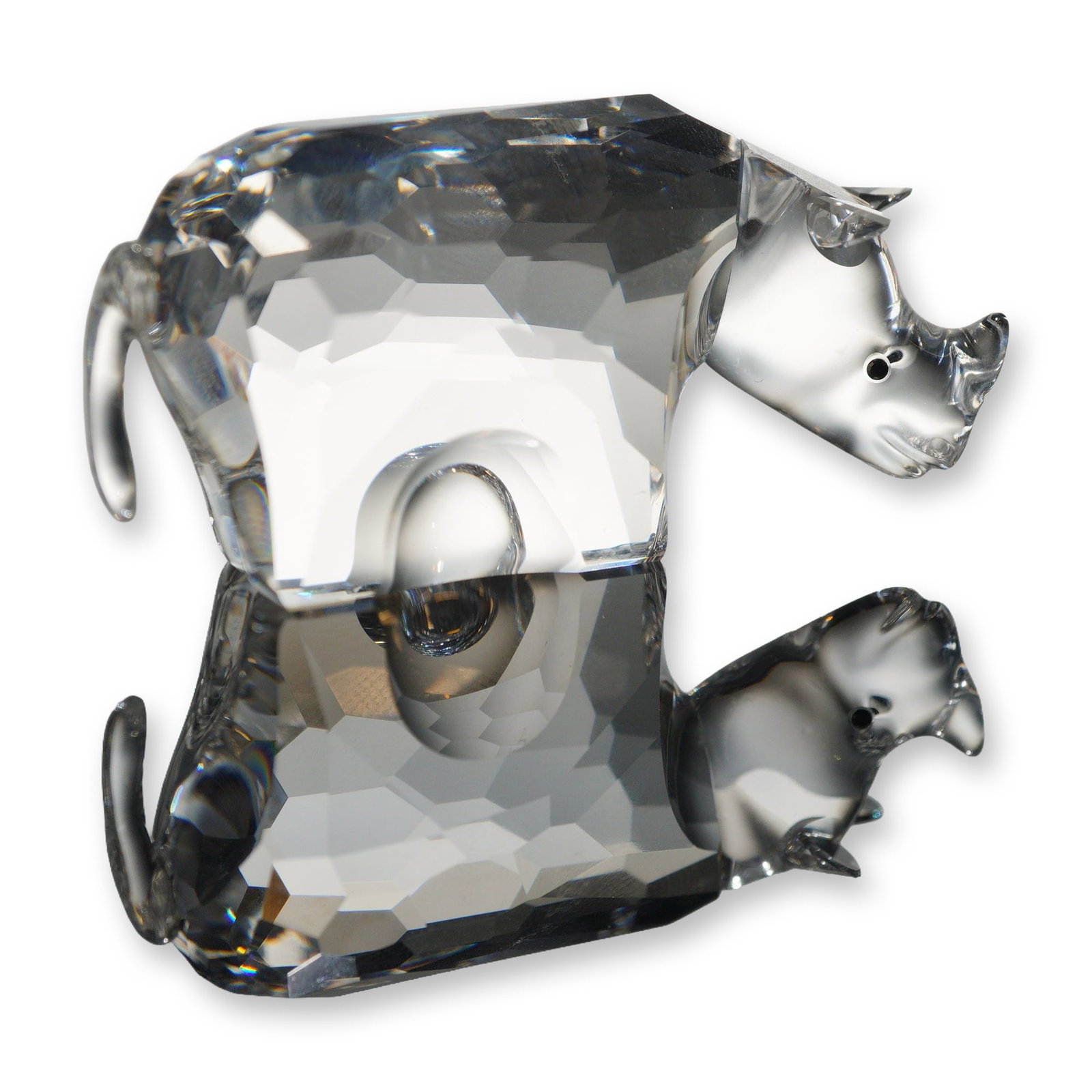 Swarovski Crystal Rhinoceros Figurine: Swarovski crystal figurine representing a Rhino. Crafted in clear faceted and molded lead crystal, the rhinoceros features a highly faceted body, a smooth head and neck, a small upturned horn, applied