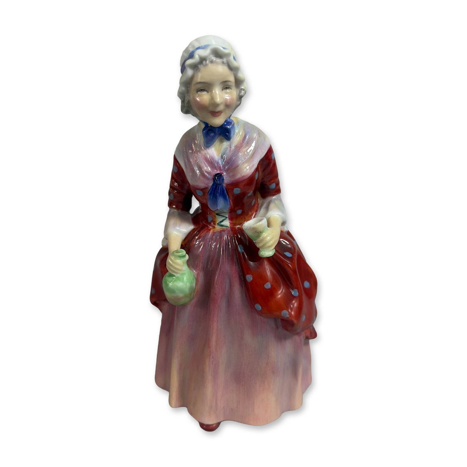Royal Doulton Jane Bone China Figurine HN 2014: Royal Doulton designed by Leslie Harradine. Standing female figure in historical-style attire, featuring a red polka-dot bodice and overskirt over a pink ruffled underskirt, with a white mob cap and b