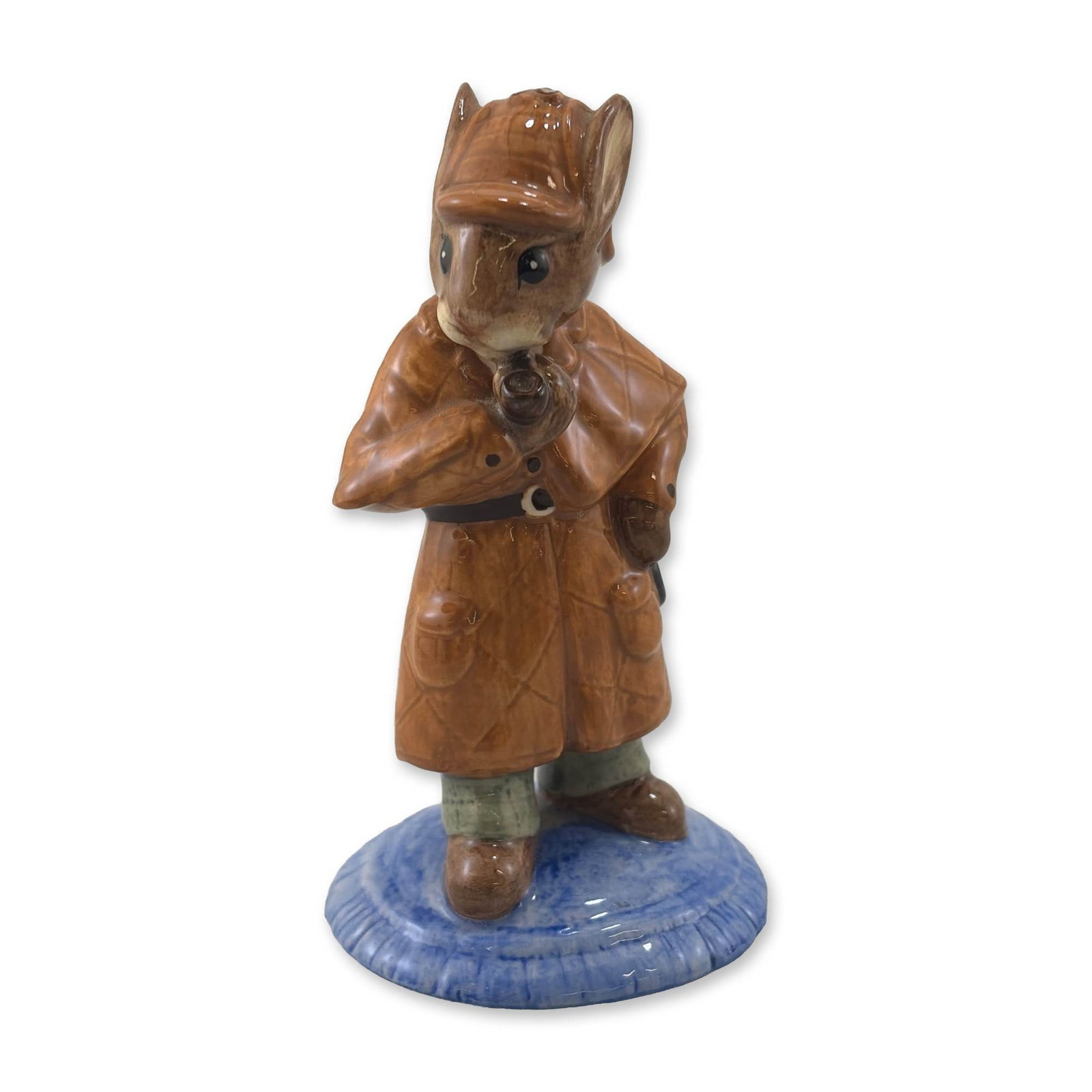 Royal Doulton Detective Bunnykins DB193 Ceramic Figurine: Royal Doulton Detective Bunnykins ceramic figurine, model DB 193. The piece depicts a rabbit in the persona of Sherlock Holmes, outfitted in a brown quilted Inverness cape and deerstalker hat while ho
