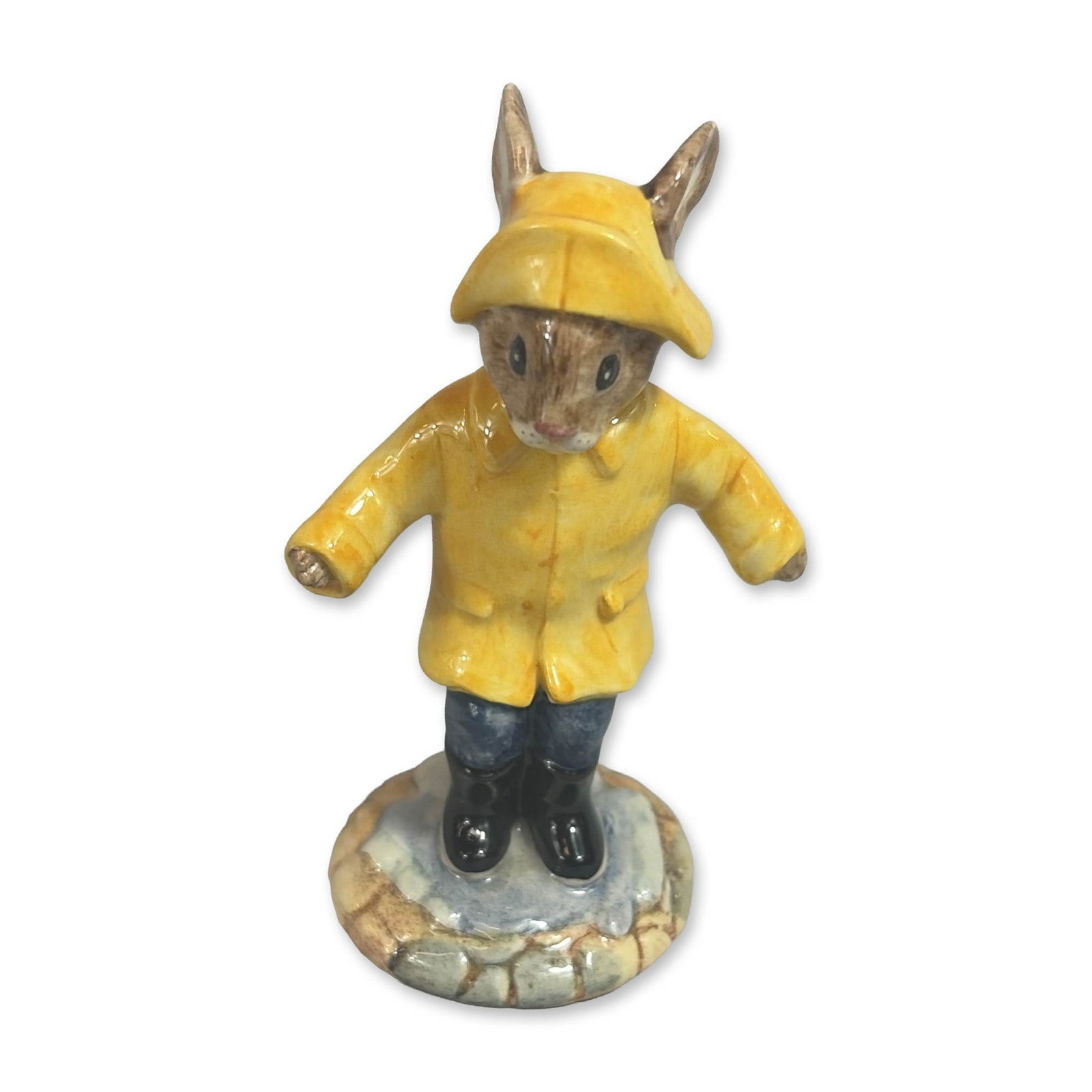 Royal Doulton Rainy Day Bunnykins Ceramic Figurine DB147: Royal Doulton, England. Glazed ceramic Bunnykins figurine titled Rainy Day, model DB 147. The piece features a rabbit character in a hooded yellow raincoat and matching hat, with dark blue trousers an