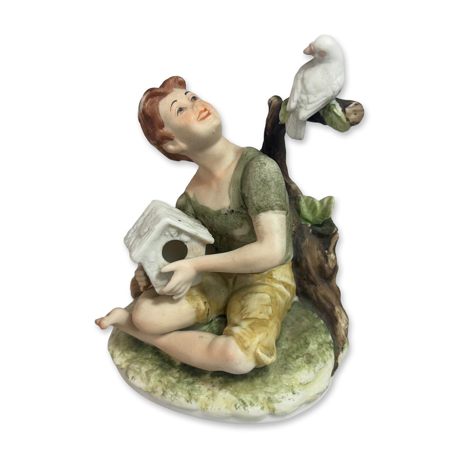 Lefton China Porcelain Figurine, Dante Boy with Birdhouse: Lefton China. Figurine in hand painted bisque porcelain, depicting a young boy in rustic attire seated on a grassy mound. The figure, often referred to as the Dante model, is shown holding a white dov