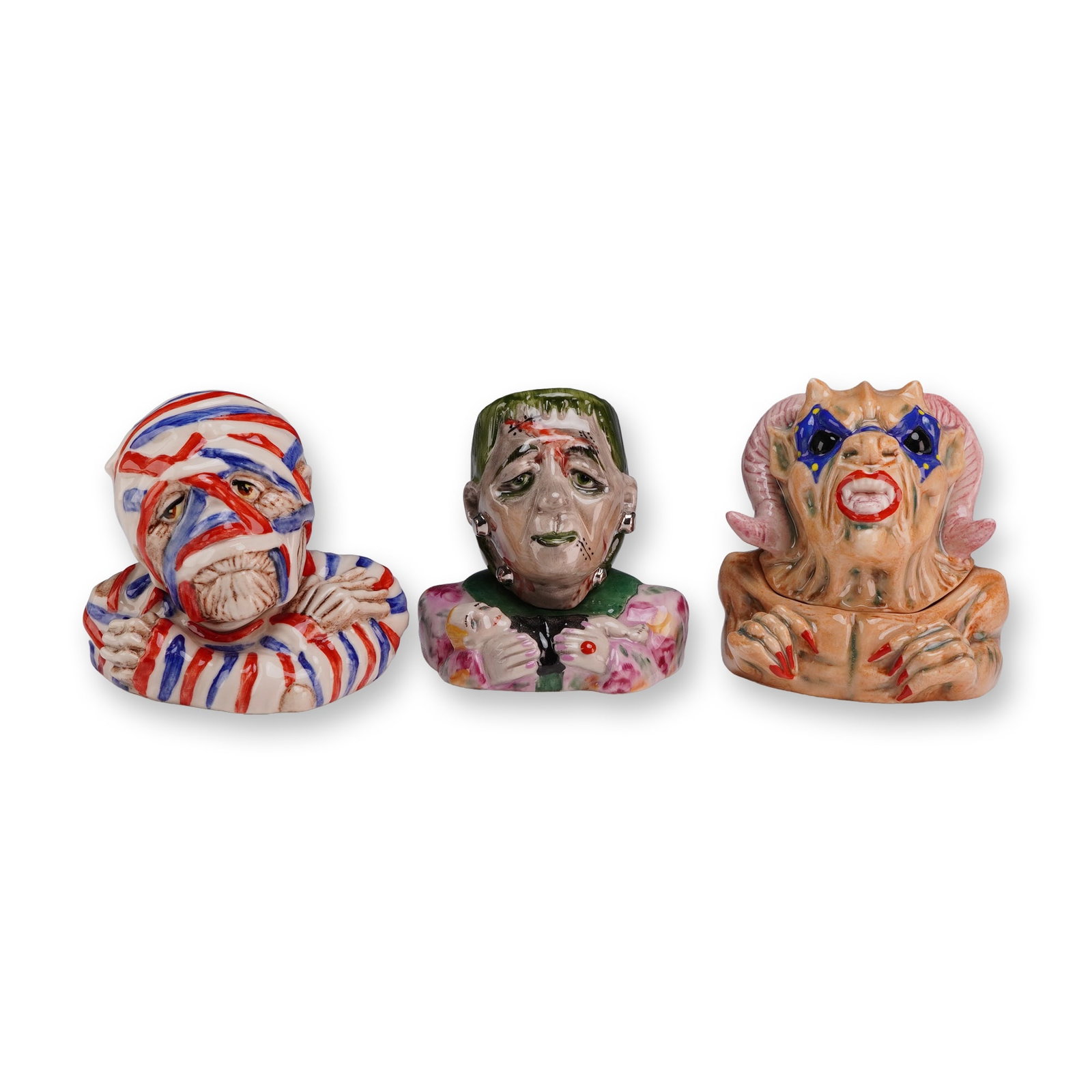Three Kevin Francis Face Pots, Monsters including Artist Edition and Prototypes: The collection includes three distinct monster-themed designs: The Mummy, Frankenstein's Monster, and The Demon. The Mummy pot is modeled as a figure wrapped in white bandages with alternating red and
