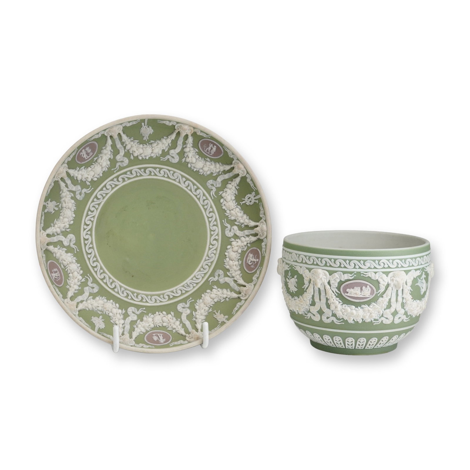 2pc Wedgwood Tri-Color Jasperware Green Tea Bowl and Saucer: This lot consists of a Wedgwood tri-color jasperware tea bowl and matching circular saucer. The set is crafted from sage green jasper dip stoneware featuring sprigged bas-relief decoration in white an