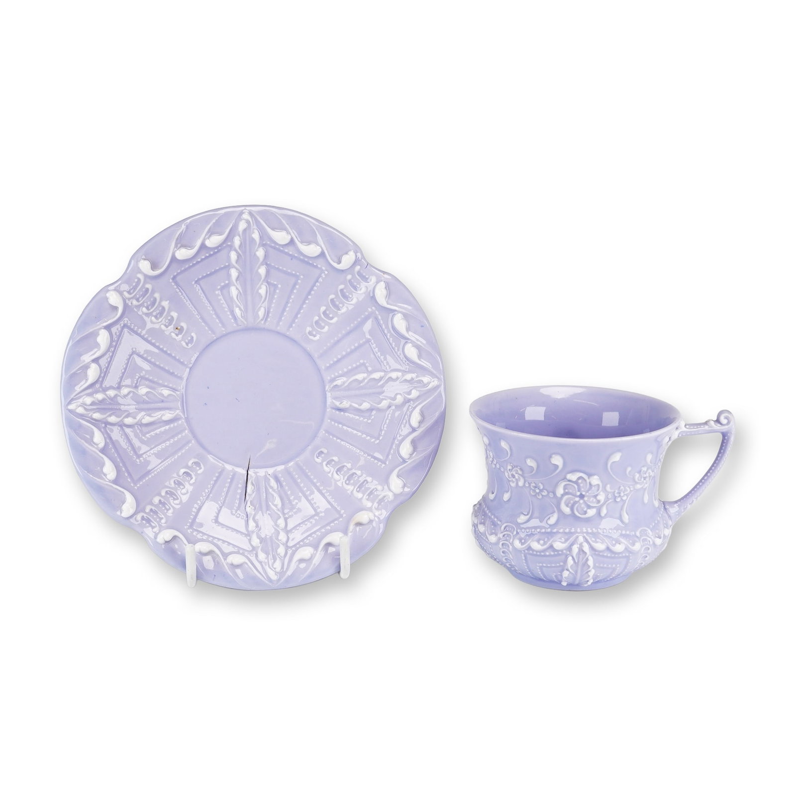 2pc Wedgwood Queen's Ware Lilac Glazed Demitasse Cup and Saucer: This set comprises a Wedgwood Embossed Queen's Ware demitasse cup and saucer. The pieces are finished in a vibrant lilac glaze featuring white sprigged relief decoration in a neoclassical style. The o