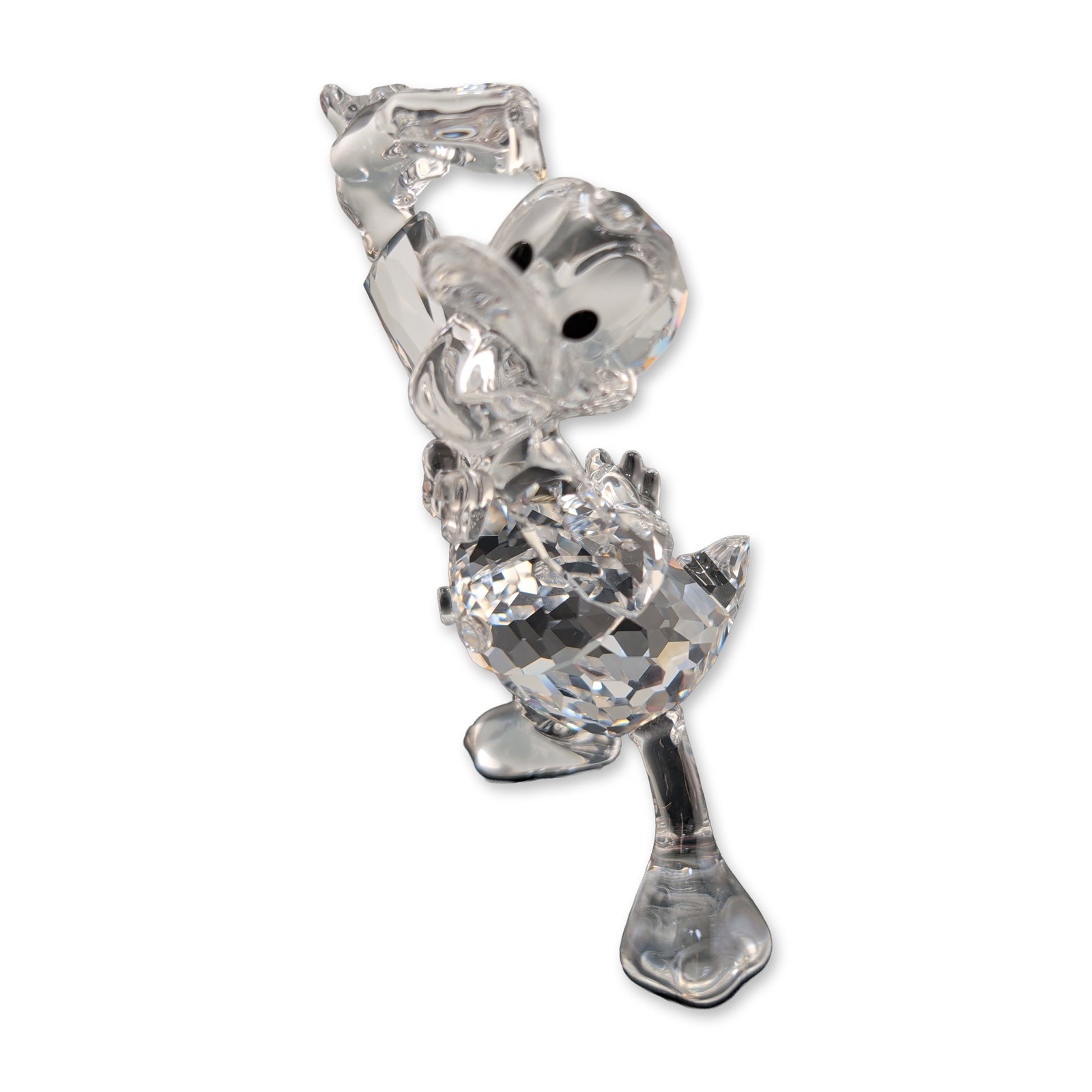 Swarovski Disney Donald Duck Crystal Figurine: Swarovski Disney figurine in clear faceted crystal with jet-colored eyes, including its original navy blue box and featuring an etched swan logo and copyright mark to the underside of the foot. Dimens
