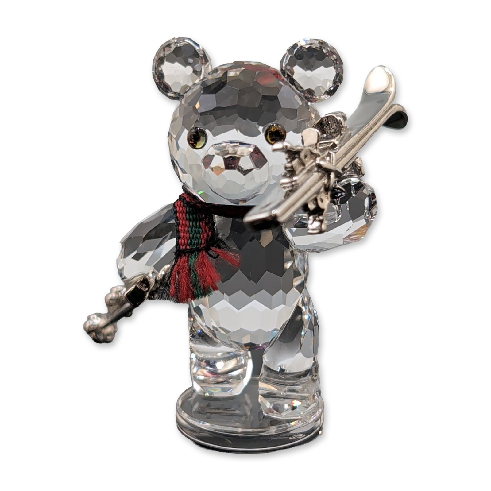 Swarovski Crystal Figurine, Kris Bear with Skis: Swarovski faceted clear lead crystal figurine, Kris Bear with Skis, model number 234710. The bear features iridescent eyes, accented with a red and green striped fabric scarf. The figure holds two ski