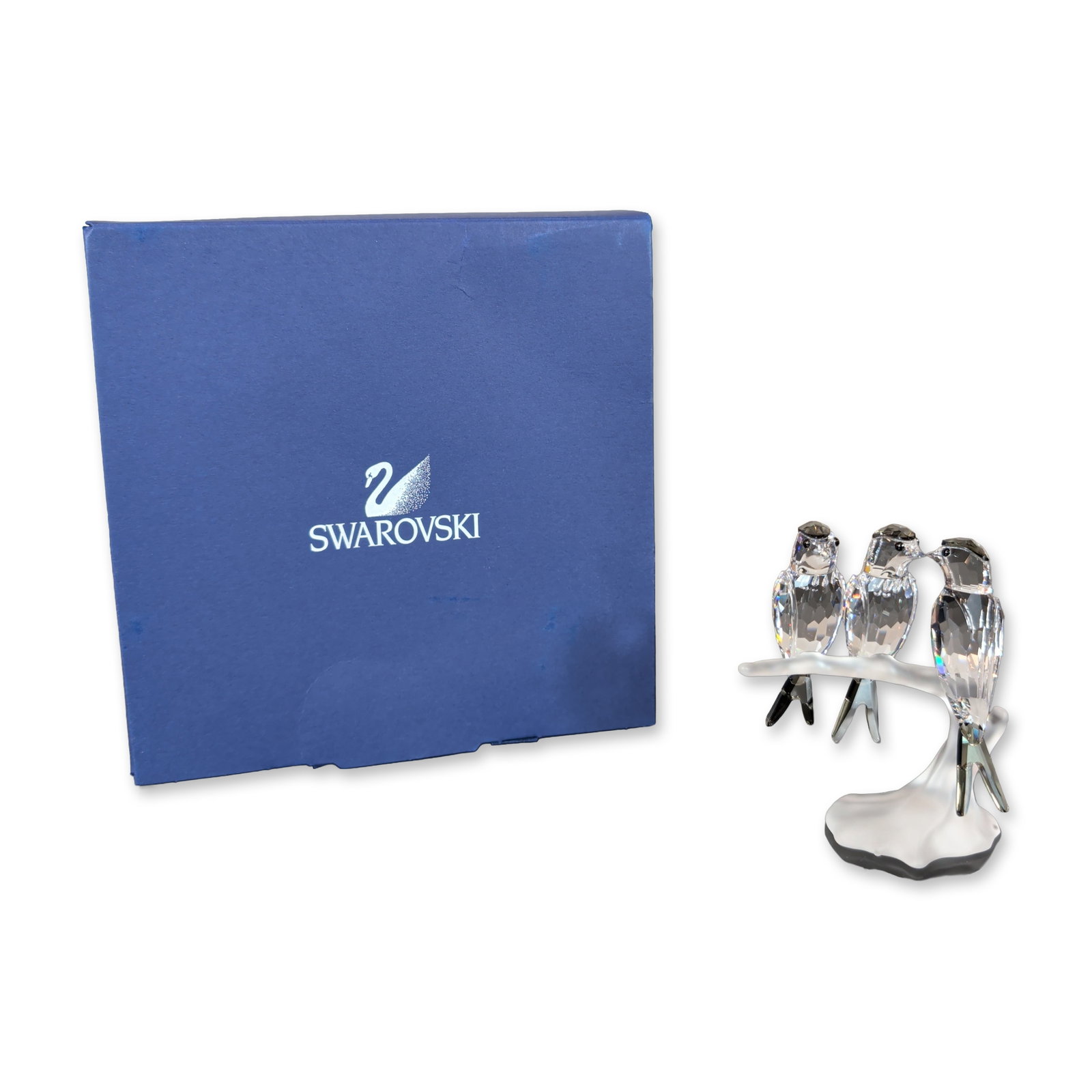 Swarovski Crystal Figurine, Swallows: A trio of Swallows figurine in faceted clear and molded frosted lead crystal. The piece features three small birds with black bead eyes perched on a frosted branch base. Bearing the incised Swarovski 