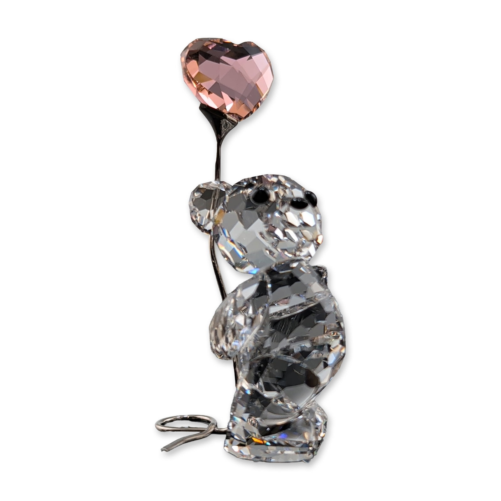 Swarovski Crystal Figurine, Kris Bear - I Love You with Pink Heart Balloon: Kris Bear collection figurine in faceted lead crystal, depicted standing and holding a silver-tone metal stem with a pink faceted crystal heart. The figure features black crystal accents for the eyes 