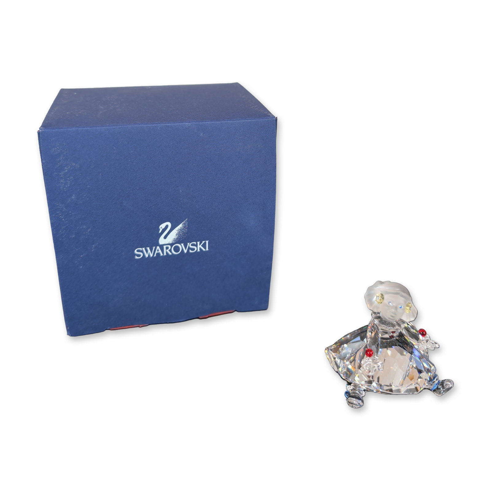 Swarovski Crystal Puppet Figurine: Swarovski crystal figurine of the Puppet from the When We Were Young series. The figurine in clear faceted and frosted crystal, features a seated character holding a large multifaceted clear crystal. 