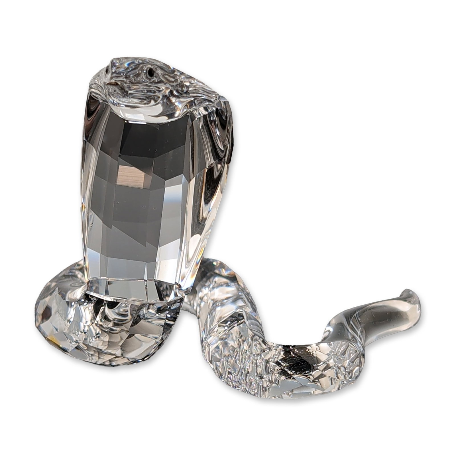 Swarovski Silver Crystal Figurine, Cobra: Swarovski figurine of a cobra snake crafted from faceted clear lead crystal. The design features a coiled body transitioning into a smooth-polished neck and flared hood, accented with two small dark i