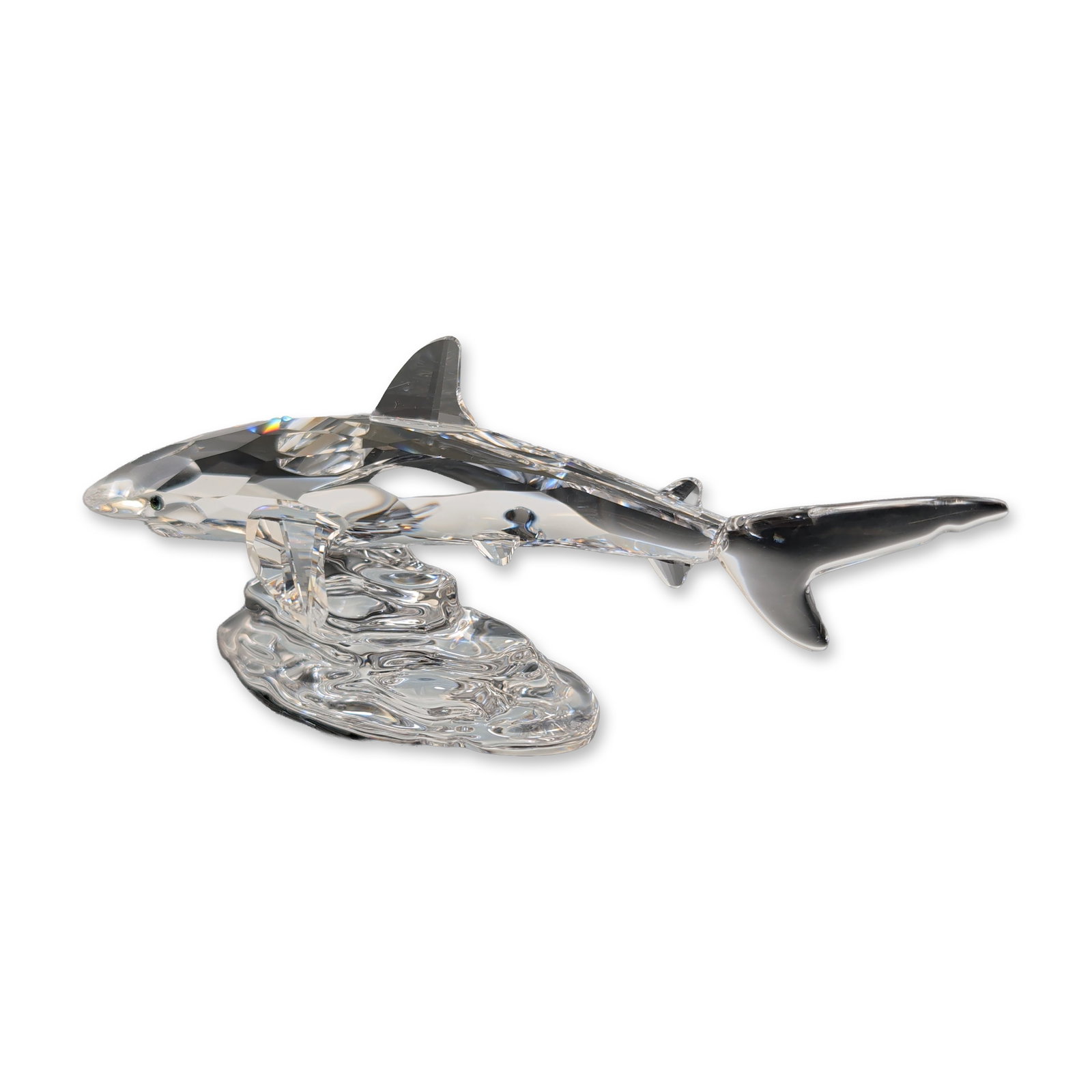 Swarovski Crystal Figurine Baby Shark by Anton Hirzinger: Swarovski Silver Crystal figurine in clear faceted lead crystal depicting a baby shark breaching from a textured, rippled water-effect base. Designed by Anton Hirzinger for the South Sea collection. M