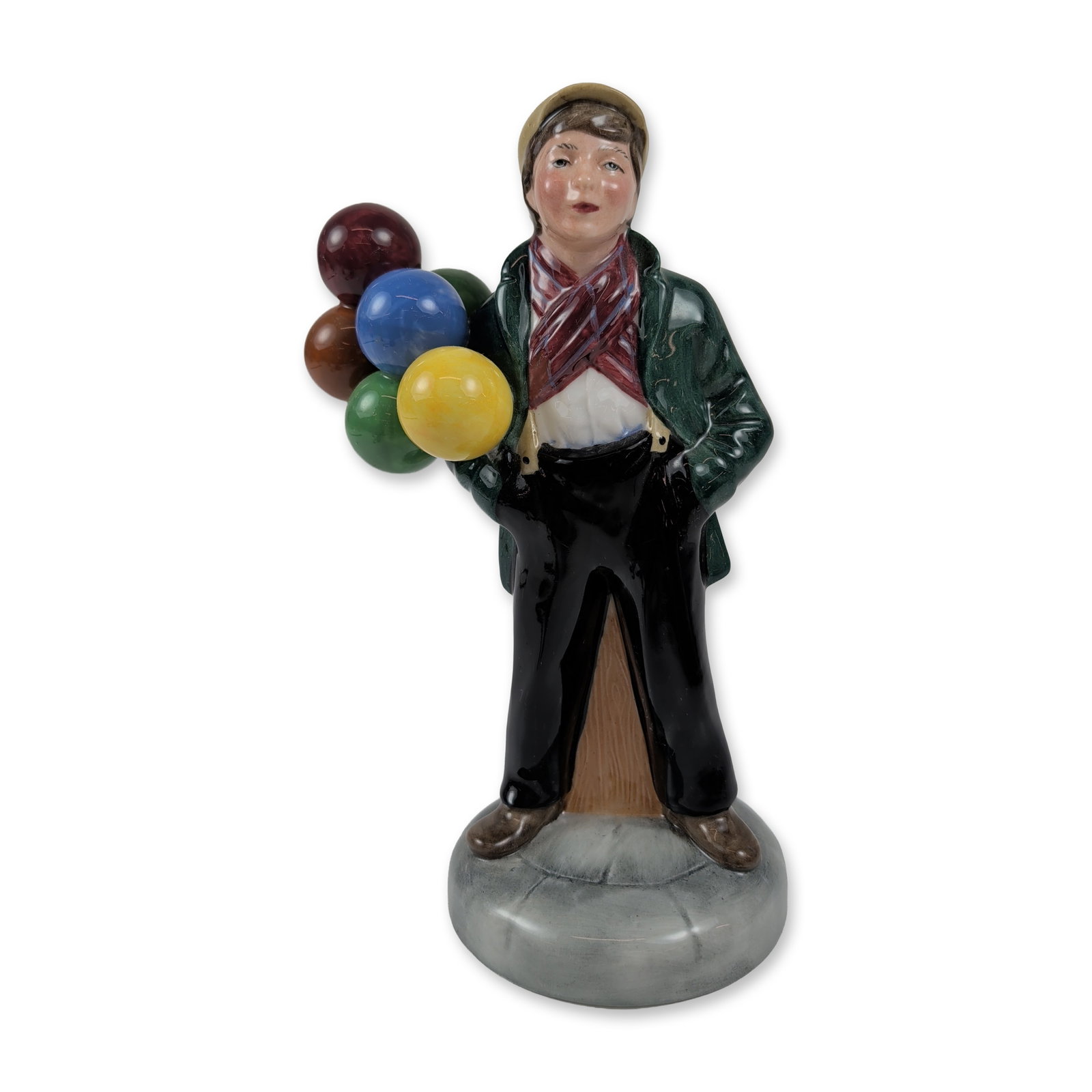 Royal Doulton Balloon Boy Porcelain Figurine HN2934: Designed by Peter A. Gee, this charming molded figure portrays a young boy in a dark green overcoat and a red patterned scarf, clutching five colorful balloons as he leans casually against a fence pos