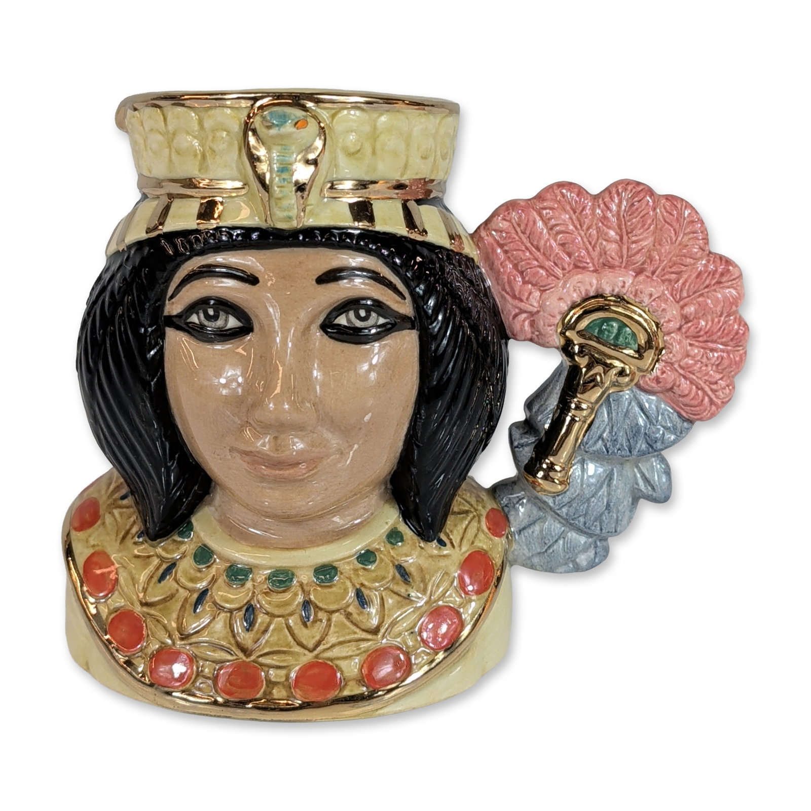 Royal Doulton Ankhesenamun Small Character Jug D7128: Royal Doulton (England). Character jug in glazed ceramic, model D7128, titled Ankhesenamun. The figure is modeled with a black bobbed hairstyle, a golden crown featuring a uraeus, and an ornate wesekh