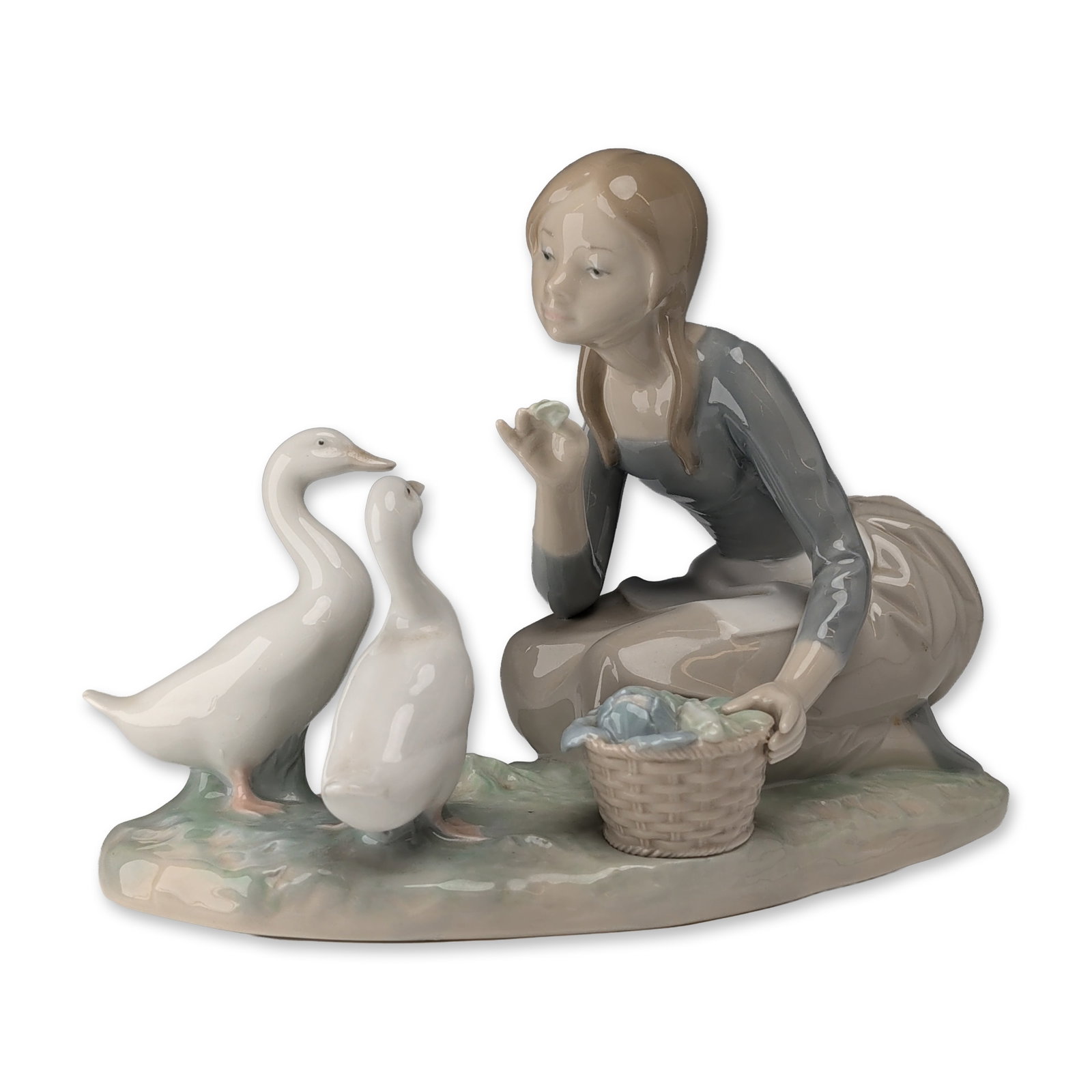 Lladro Porcelain Figurine Feeding The Ducks 4849: Lladro (Spain). Figurine titled Feeding The Ducks, model number 4849, in glossy glazed porcelain, featuring a kneeling young woman in a grey-blue bodice and taupe skirt feeding two geese from her hand