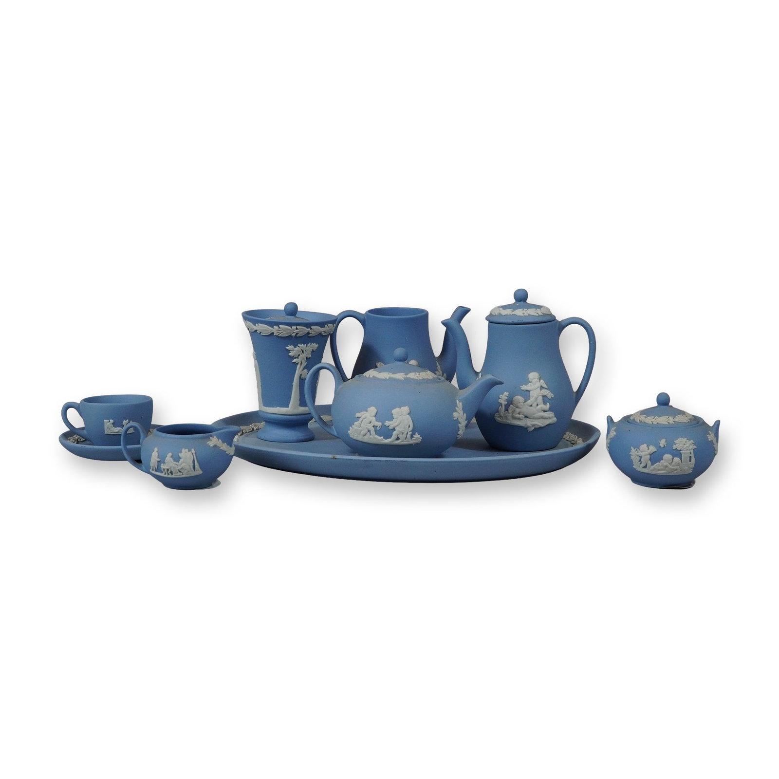 9pc Wedgwood Miniature Blue Jasperware Tea and Coffee Service Pieces: This collection of miniature blue Jasperware from Wedgwood, England, consists of eight components featuring white sprigged neoclassical relief decoration on unglazed light blue stoneware. The set incl