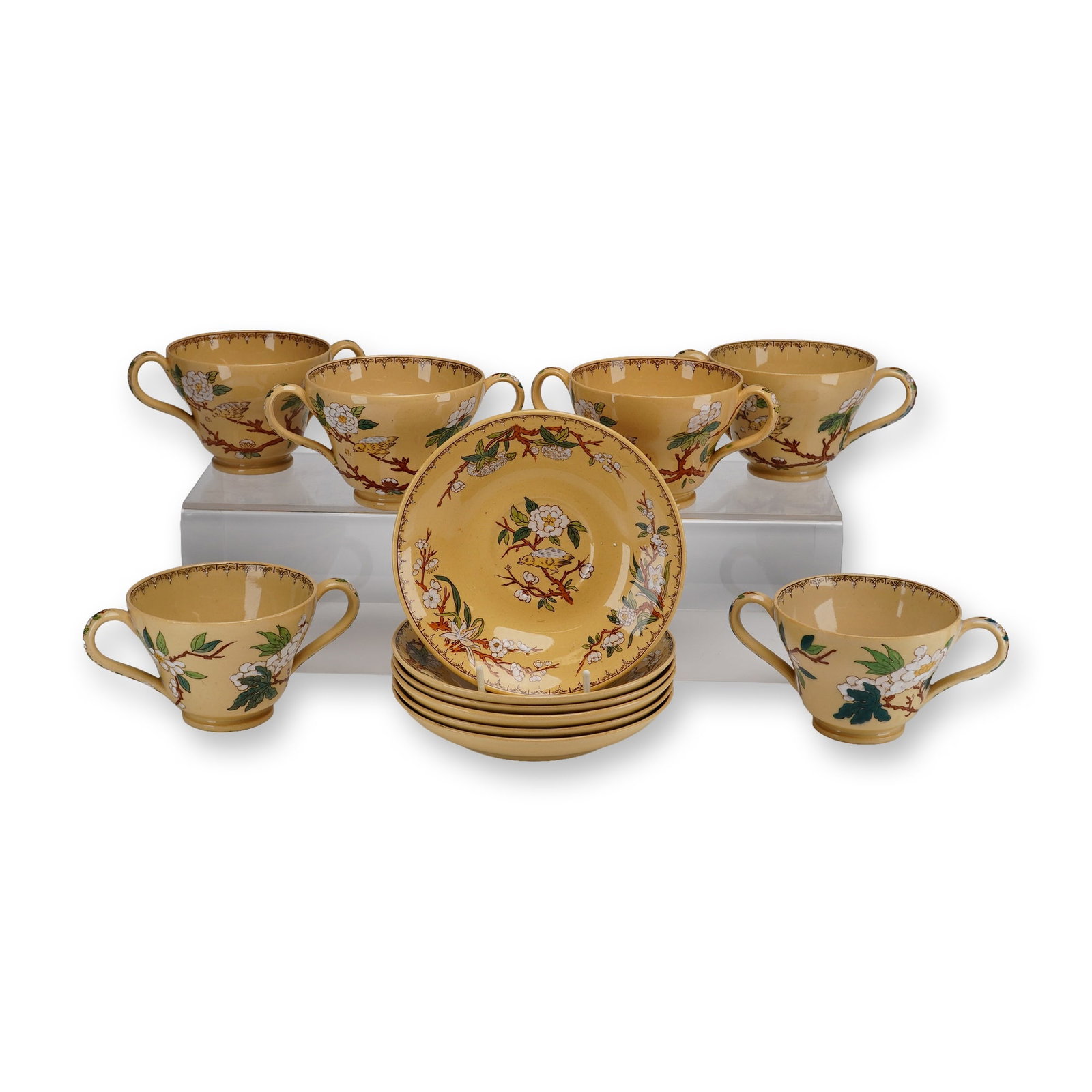Set of Twelve Wedgwood Etruria Bouillon Cups and Saucers in the Cuckoo Pattern: A set of twelve ceramic pieces by Wedgwood in the Cuckoo pattern, consisting of six double-handled bouillon cups and six matching saucers from the collection of Dr. Ellis F. and Suzanne Borow Rubin. T
