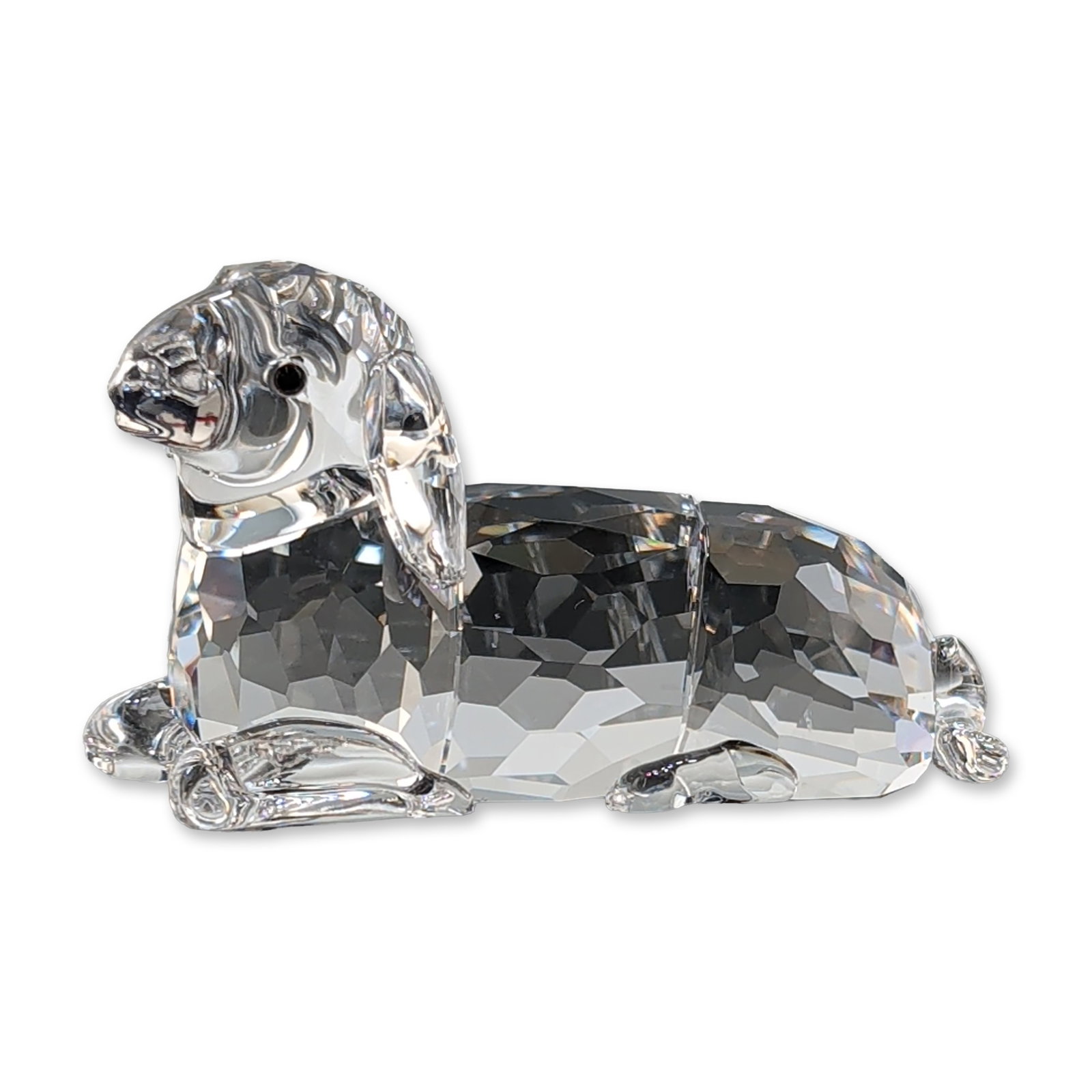 Swarovski Crystal Sheep Mother Lying Figurine: Swarovski faceted clear crystal figurine of a mother sheep. The piece features a faceted body with smooth face, ears, and tail, accented with small black crystal eyes. Bears an acid-etched Swarovski s