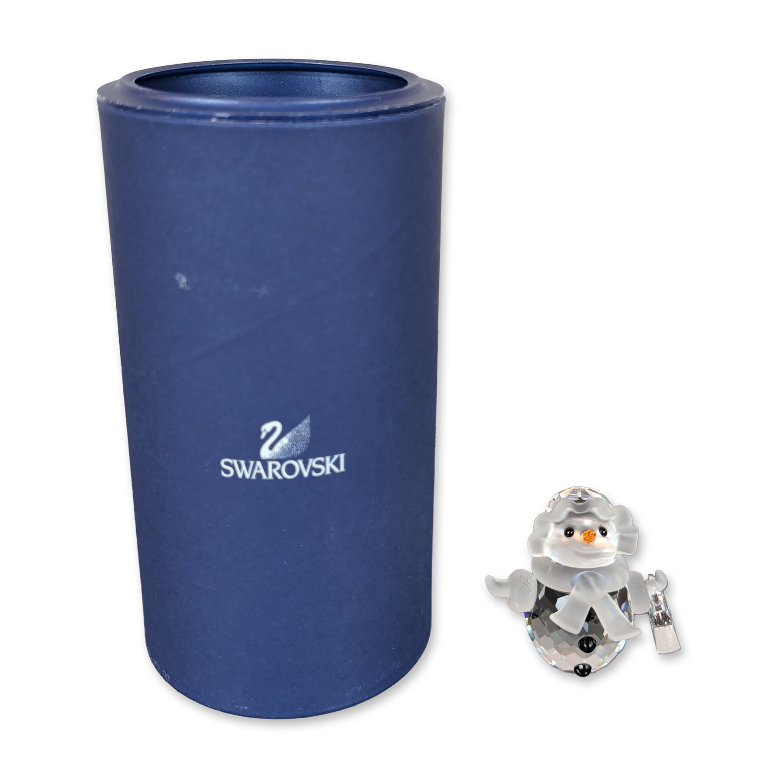 Swarovski Crystal Snow Woman Figurine with Purse: Swarovski Snow Woman figurine in faceted and frosted crystal, featuring a clear body and head with frosted arms, scarf, and hat brim. The figure is accented with an orange crystal nose and black cryst