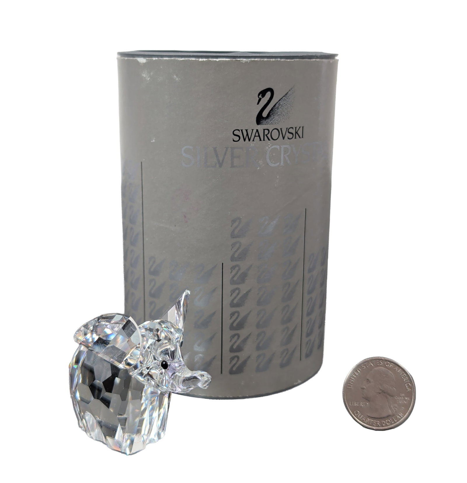 Swarovski Silver Crystal Elephant Figurine: Swarovski, Austria. Miniature elephant figurine in faceted lead crystal, featuring a lowered trunk and black inset eyes. Acid-etched swan logo on underside. Accompanied by original silver-toned cylind