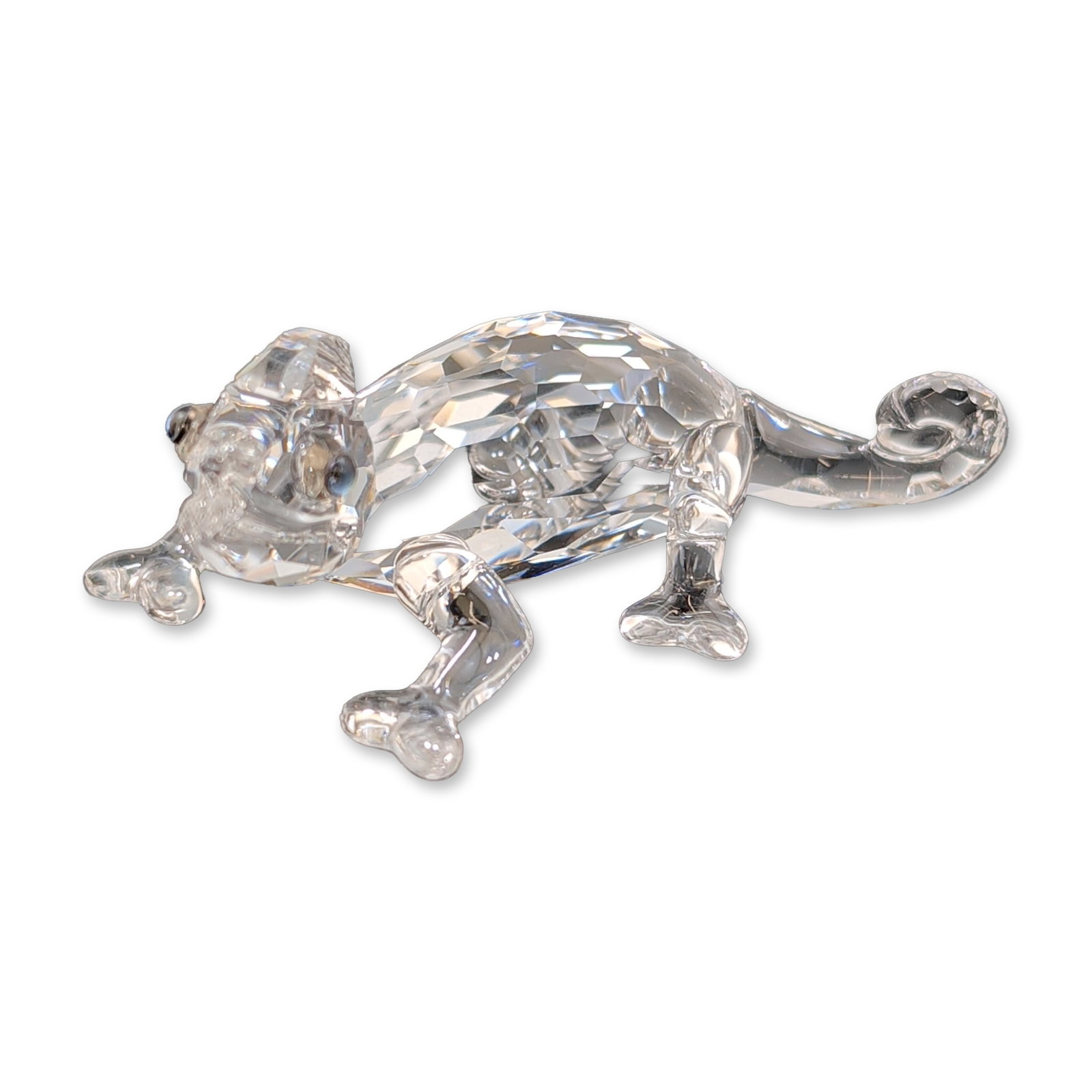 Swarovski Crystal Figurine, Chameleon with Chaton: Chameleon animal figurine in faceted and molded clear lead crystal, featuring a climbing pose with a curled tail and small dark beaded eyes. Accompanied by original blue cylindrical branded packaging.