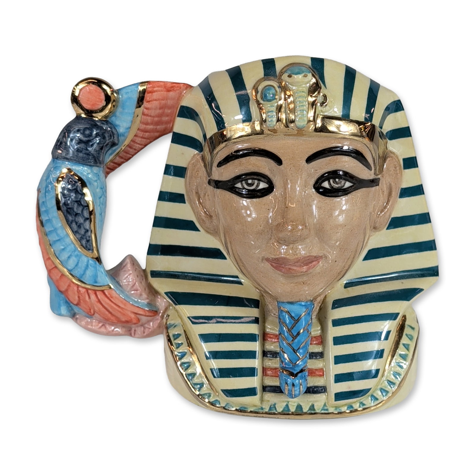 Royal Doulton Tutankhamen Small Character Jug D7127: Royal Doulton. Character jug in glazed earthenware, model D7127, depicting the Egyptian Pharaoh Tutankhamen. Features a cream and blue striped nemes headdress and ceremonial beard, with a handle model