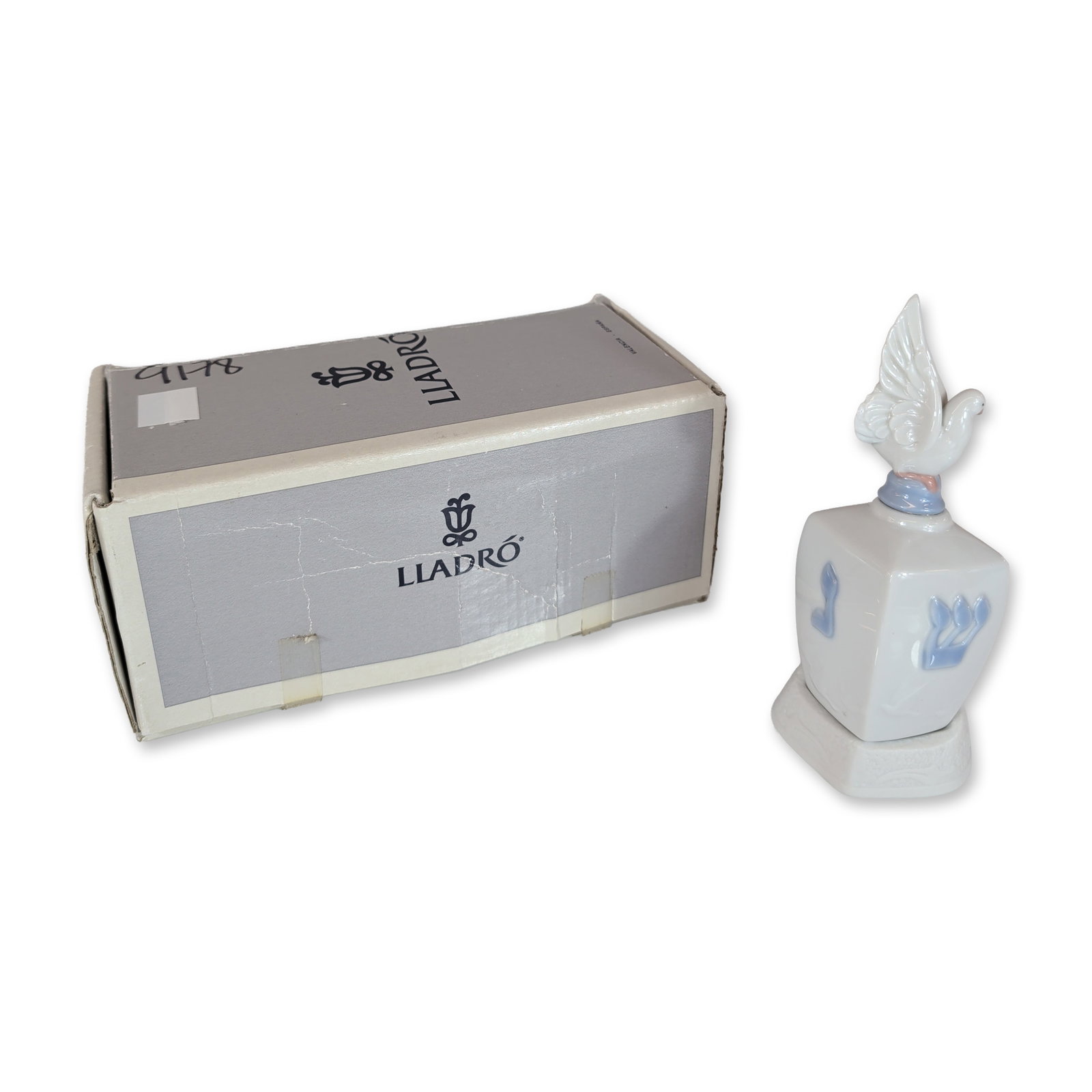 Lladro Spanish Porcelain Dreidel with Dove 01006678: Lladro (Spanish). Dreidel with Dove porcelain figurine, model number 06678, designed by Joan Coderch. This two-piece set features a white glazed porcelain dreidel with Hebrew characters hand-painted i