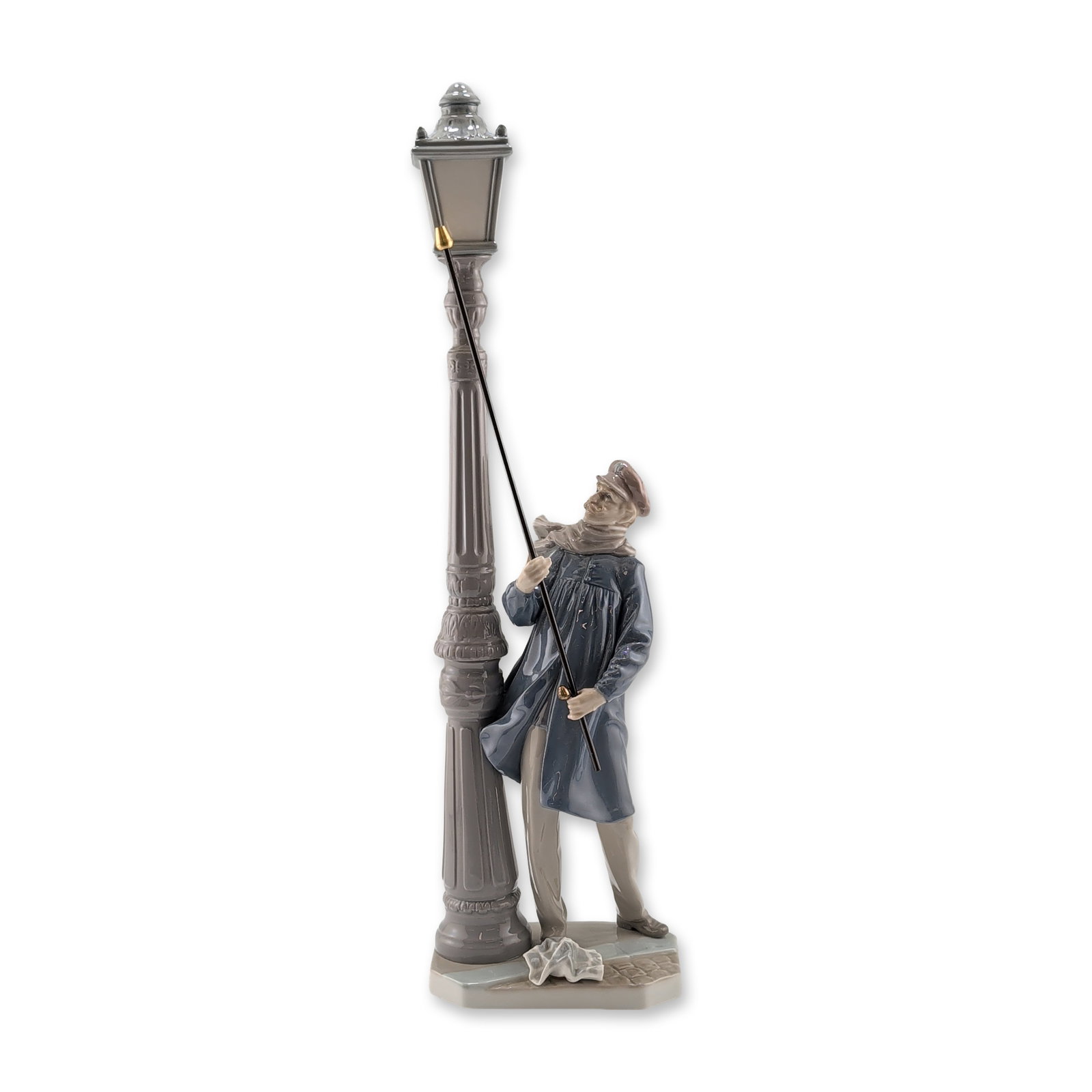 Lladro Spanish Glazed Porcelain Lamplighter Figurine 5205: Lladro glazed porcelain figurine titled Lamplighter (El Farolero), model number 5205. The sculpture depicts a man in 19th-century attire, including a long blue coat, cap, and scarf, leaning against a 