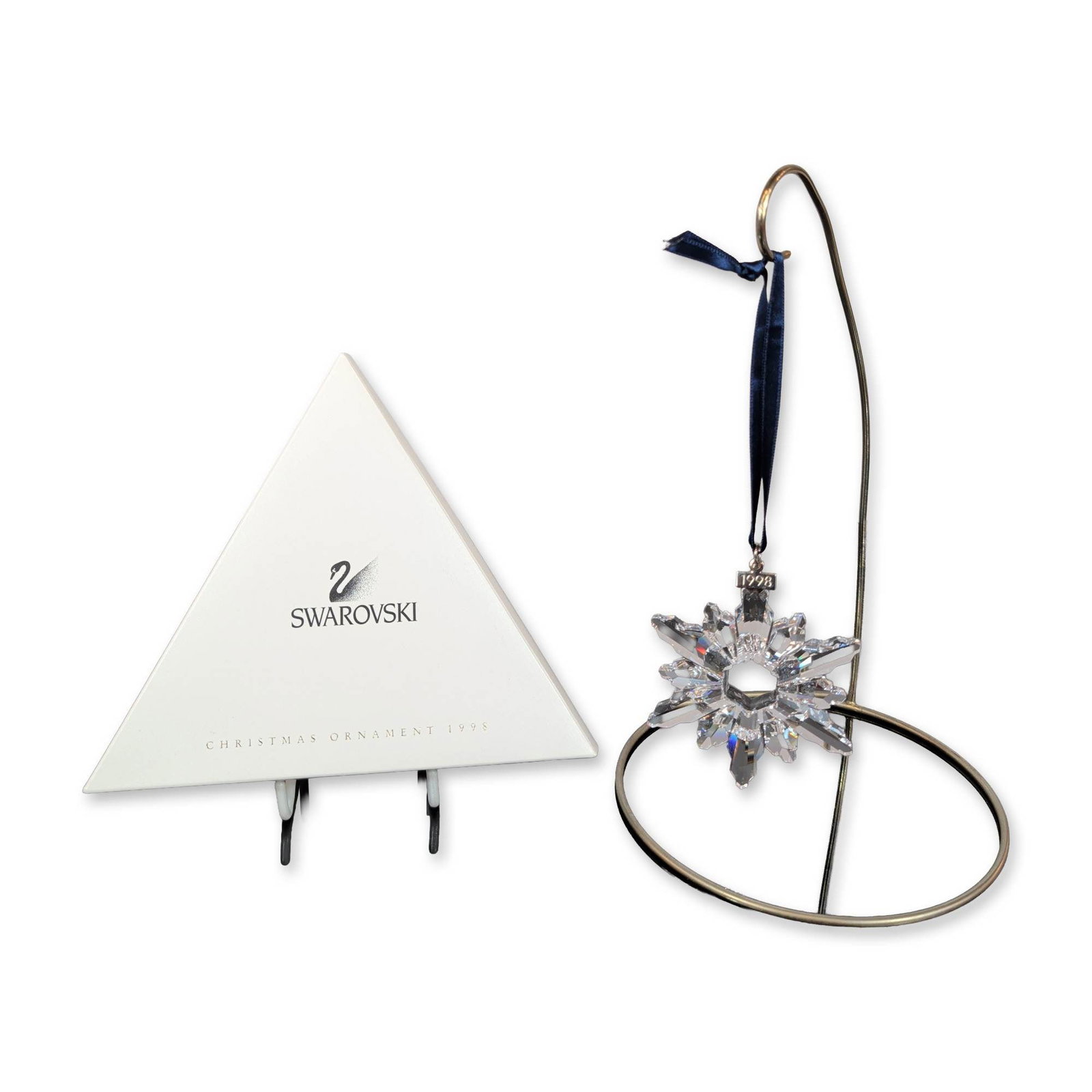 Swarovski 1998 Annual Edition Crystal Snowflake Ornament: Swarovski (Austrian). 1998 Annual Edition Christmas ornament in clear multifaceted lead crystal, designed as a six-pointed snowflake with a central hexagonal aperture. The piece is suspended from its 
