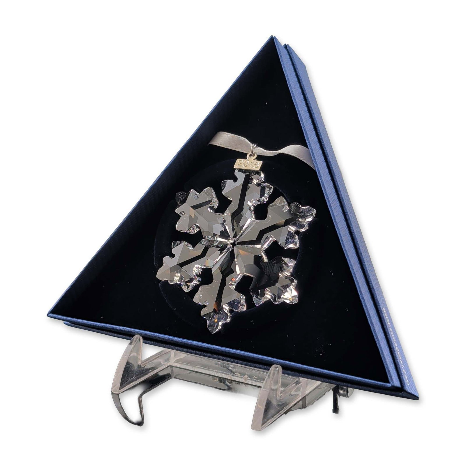 Swarovski 2016 Annual Edition Crystal Snowflake Ornament: Swarovski Annual Edition 2016 Christmas ornament. Crafted from clear multifaceted lead crystal in a six-pointed snowflake form. Features a silver-tone metal tag incised 2016 and a white satin hanging 