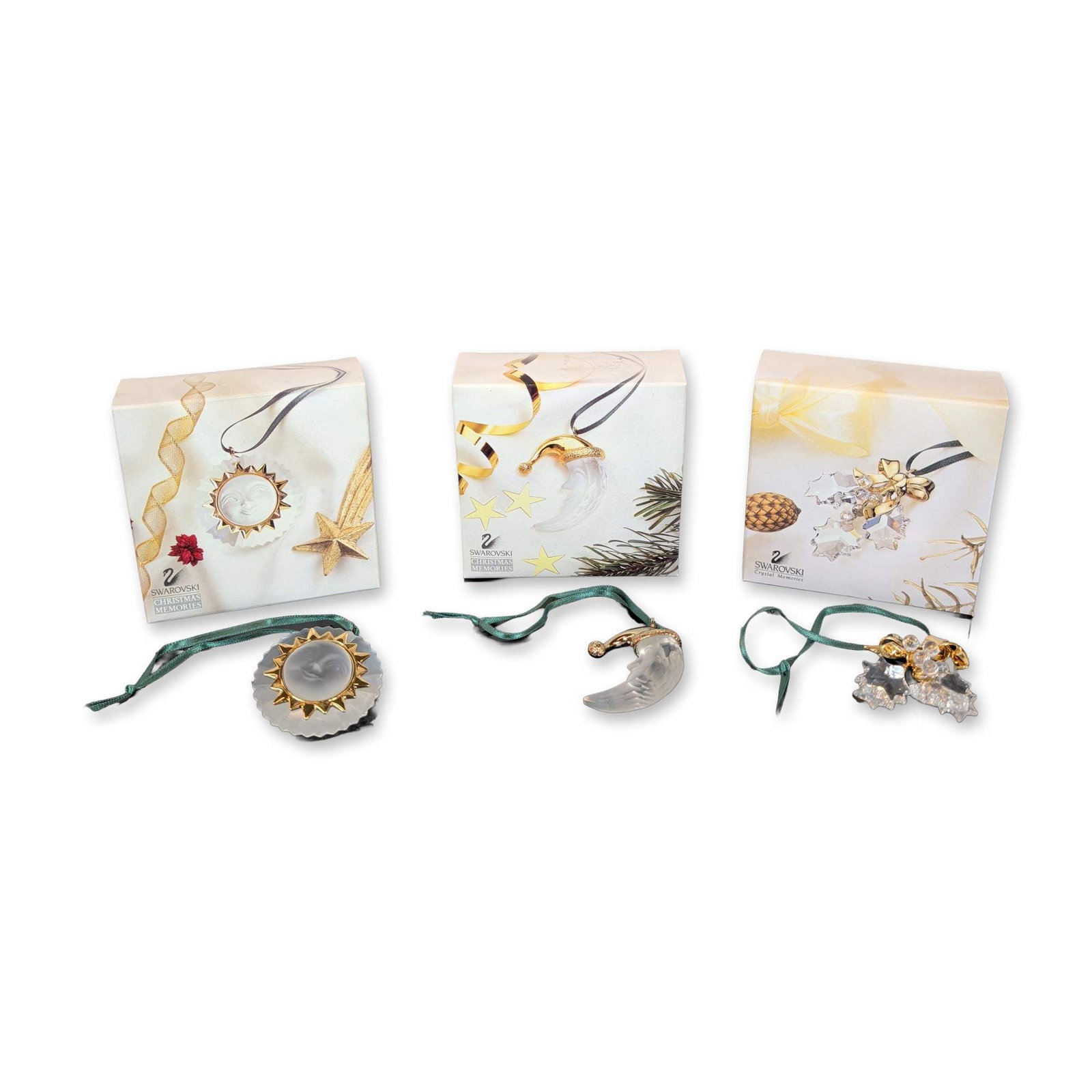 3pc Swarovski Christmas Crystal and Gold-Tone Ornaments: Swarovski trio of holiday ornaments from the Crystal Memories and Christmas Memories collections. The set includes a clear faceted crystal holly sprig with a polished gold-tone metal bow, a frosted cr