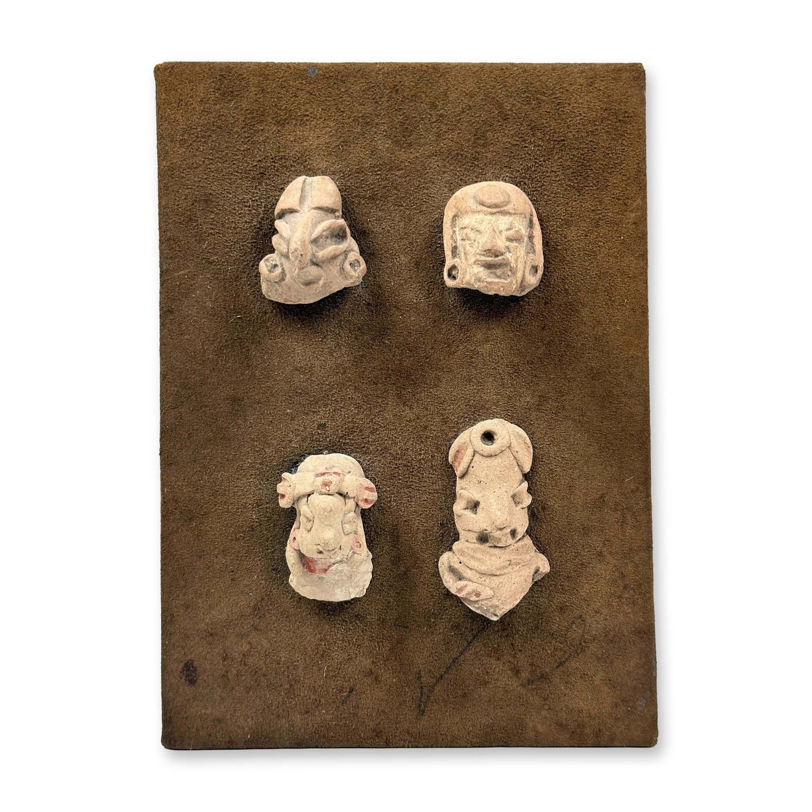 Display of Four Chupicuaro Ceramic Figurine Fragments: This lot features a collection of four ancient terracotta figurine fragments from the Chupicuaro culture of Western Mexico, dating to the Late Preclassic period (approximately 400 BCE ??" 200 CE). The