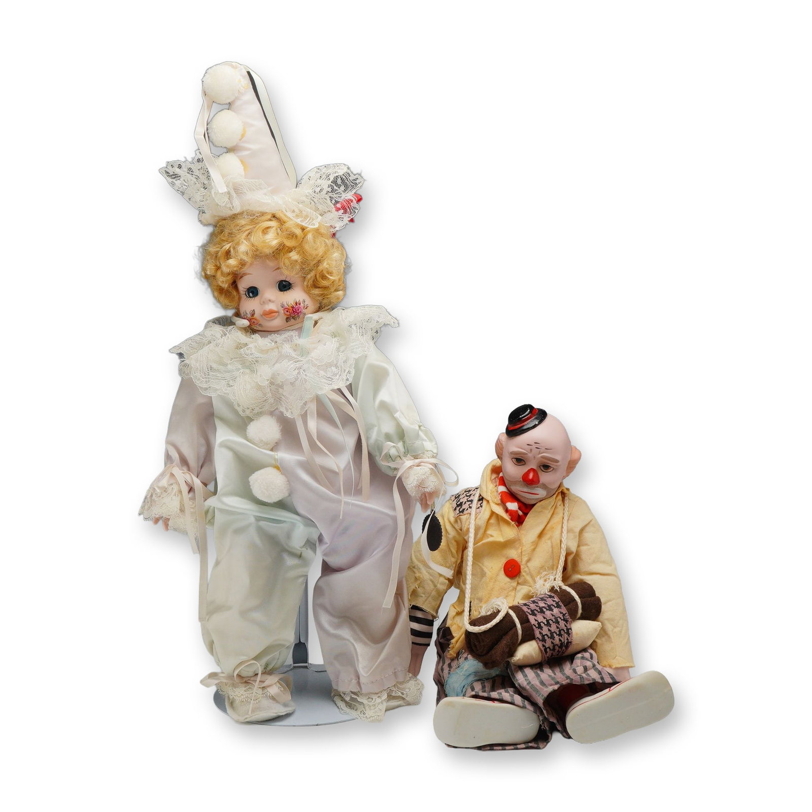 Two Vintage Porcelain Clown Dolls including Brinn Curly Clown: The clown dolls have porcelain heads, hands, and feet with fabric stuffed bodies. Brinn curly haired doll made in 1990, is dressed in satin clown suit and adorned with applied rose design on cheeks.