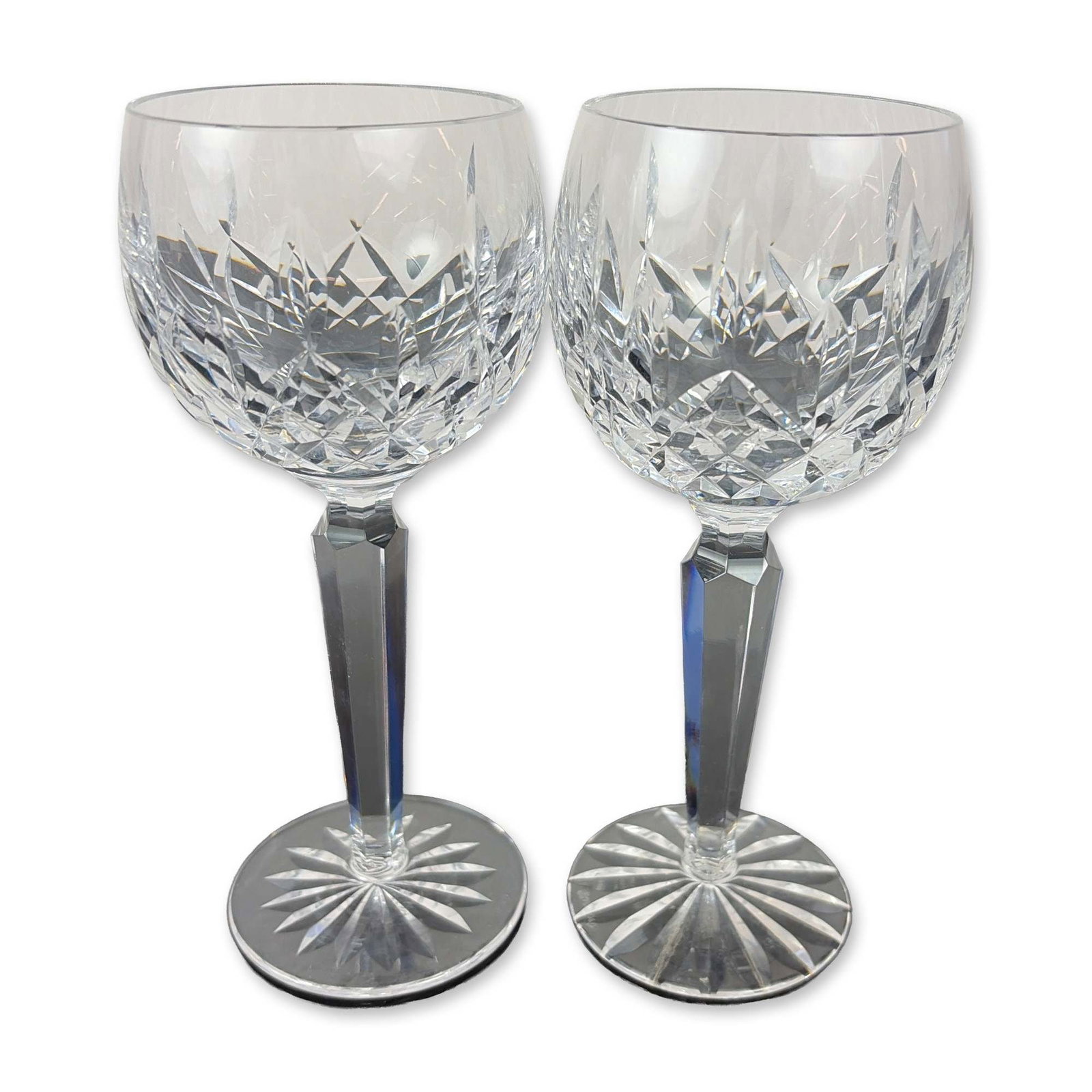 Pair of Waterford Lismore Crystal Hock Wine Glasses: Lead crystal construction featuring a bowl with deep-cut criss-cross diamond and vertical wedge patterns. The multi-faceted hexagonal stem joins to a circular foot finished with a sixteen-point