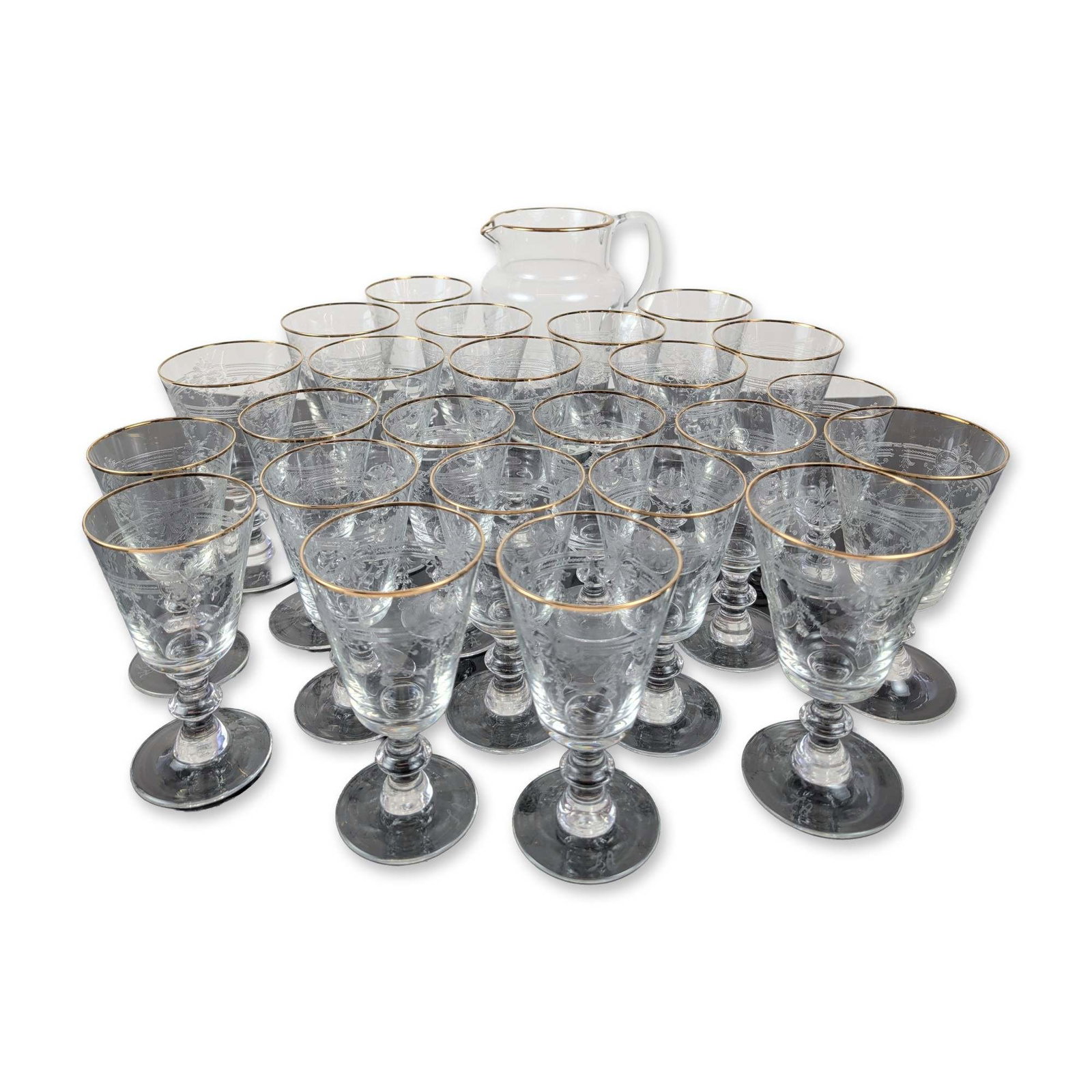 25pc Murano Style Gilt Etched Crystal Pitcher Carafe and Glassware Service: 25-piece glassware service in clear crystal, featuring etched neoclassical floral swags with hand-applied gilt rims. Goblets designed with tapered bowls, faceted triple-knopped stems, and circular fee